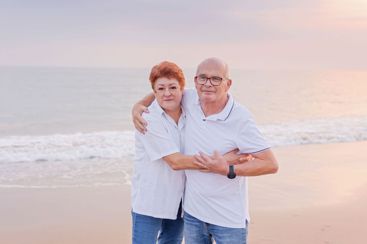 Family portraits captured on a serene beach at sunset wearing coordinated blue and white outfits.