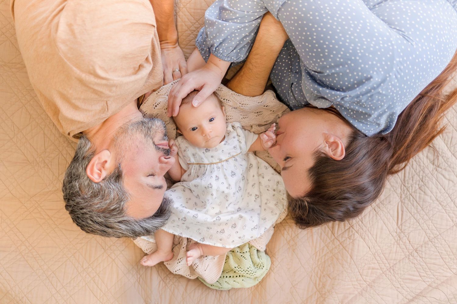 Loving family cuddle session captured in sweet side view on couch.