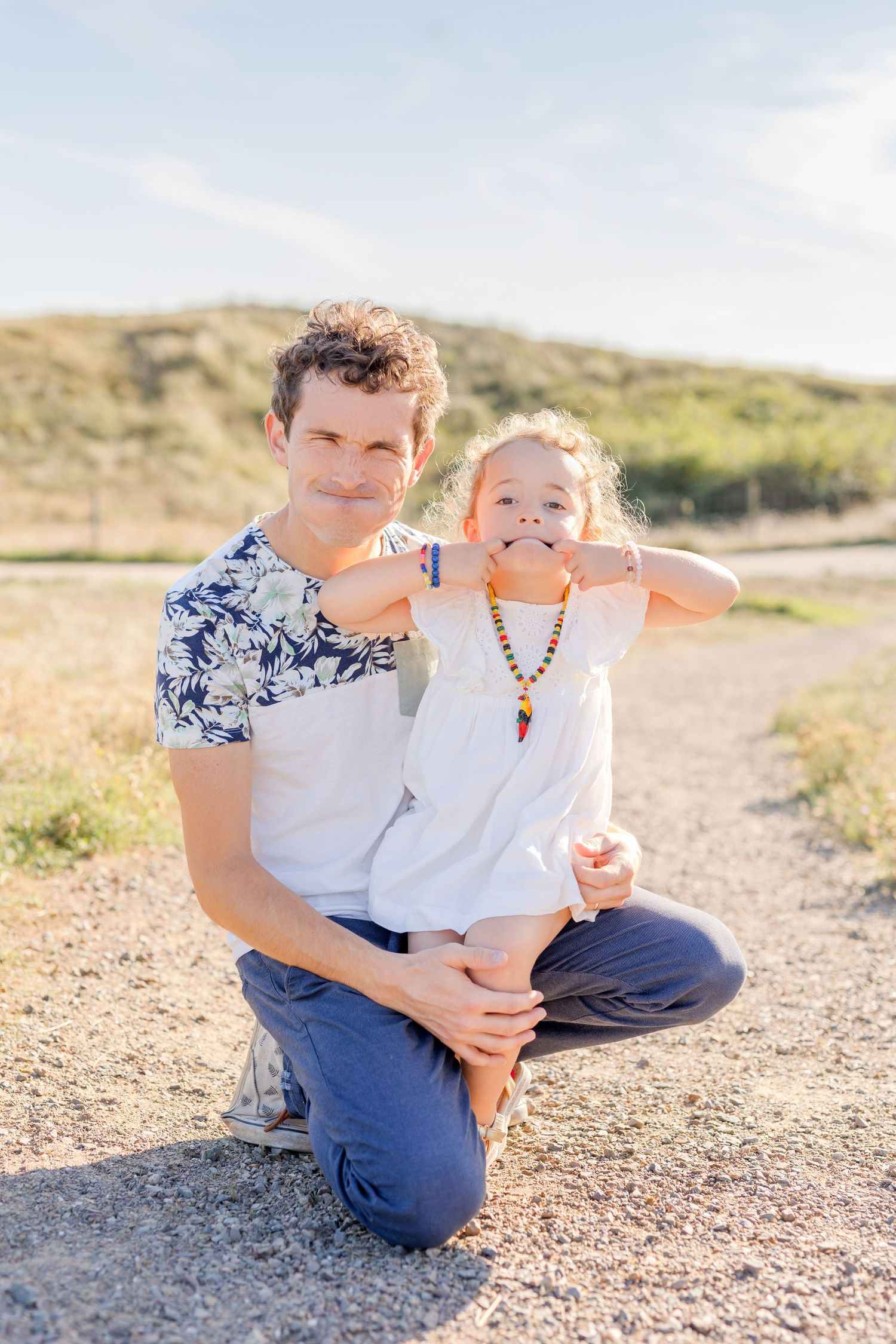 Loving family moment captured outdoors against a natural landscape backdrop.