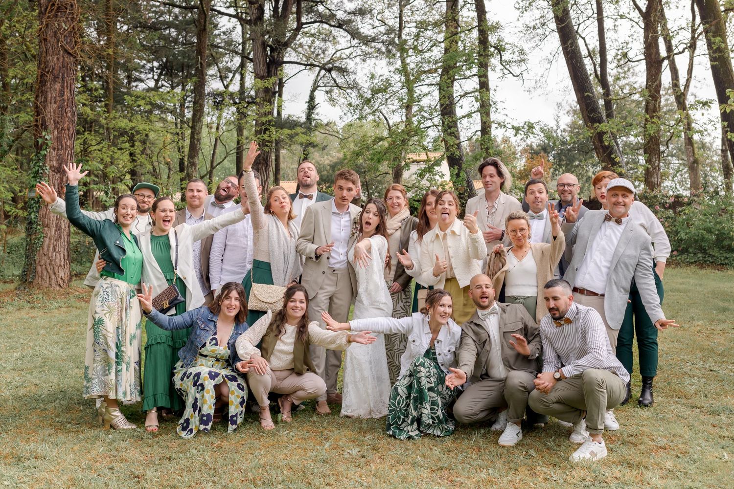 Wedding party celebrating outdoors in casual attire and floral dresses.