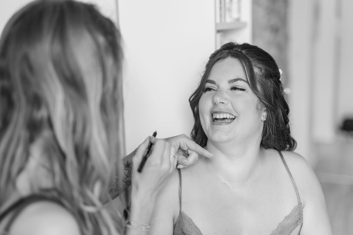 A black and white candid photo capturing a moment of genuine laughter.