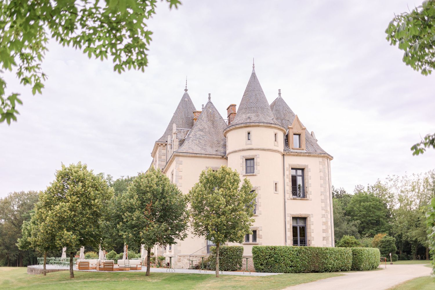 French chateau-style building with multiple turrets surrounded by manicured gardens.