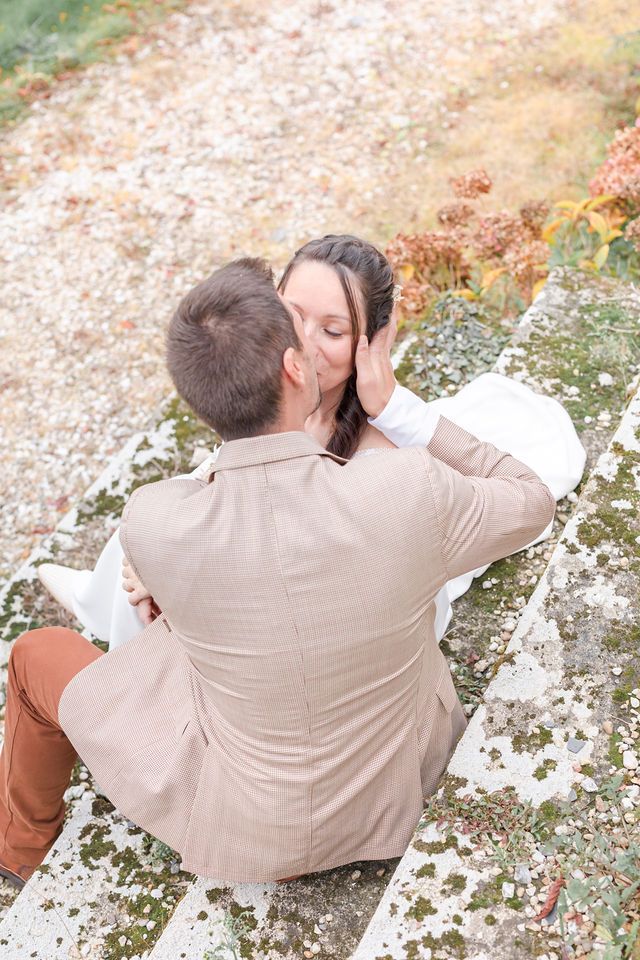 Overhead view of a wedding couple sharing an intimate moment on stone steps.