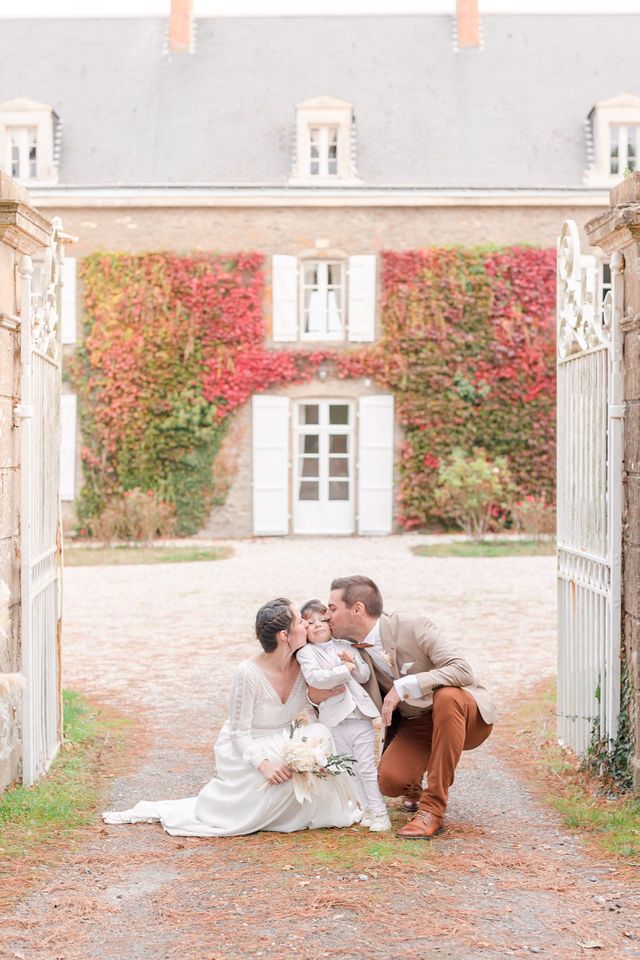 Intimate family portrait on a gravel path with vine-covered chateau backdrop.
