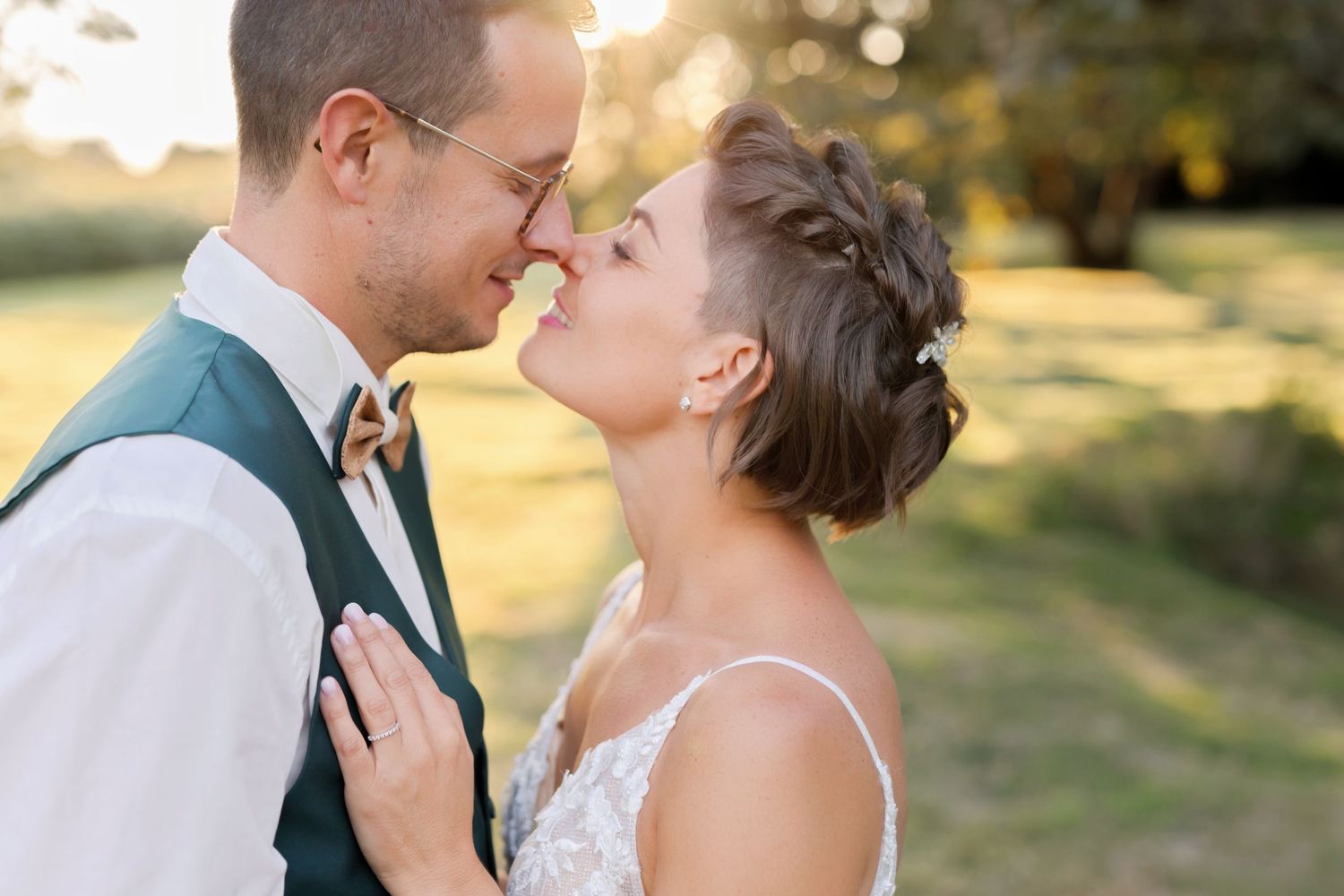 Intimate wedding portrait of a couple sharing a tender moment at sunset.