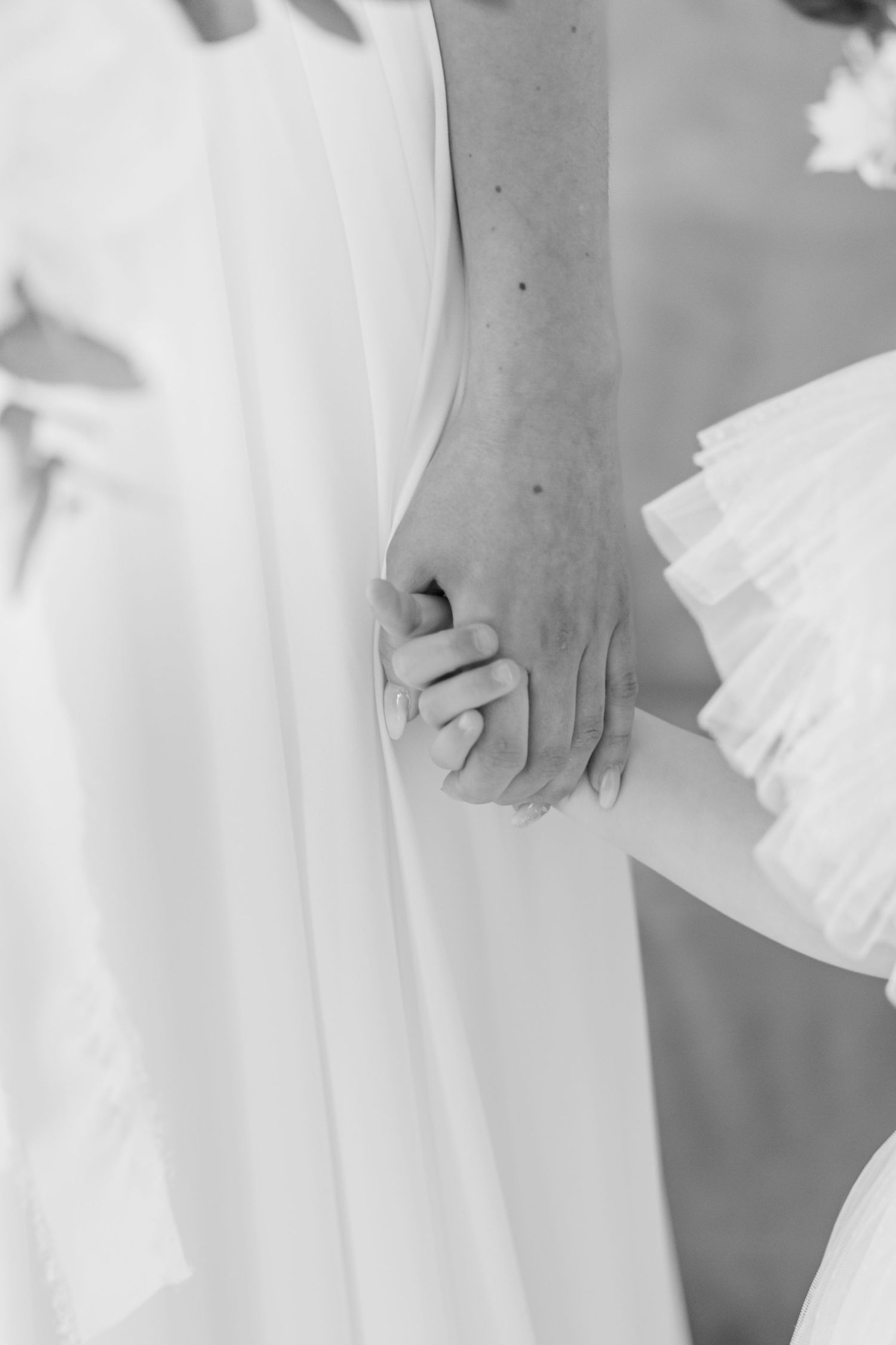 Close-up details of delicate white wedding dress fabric and embellishments.