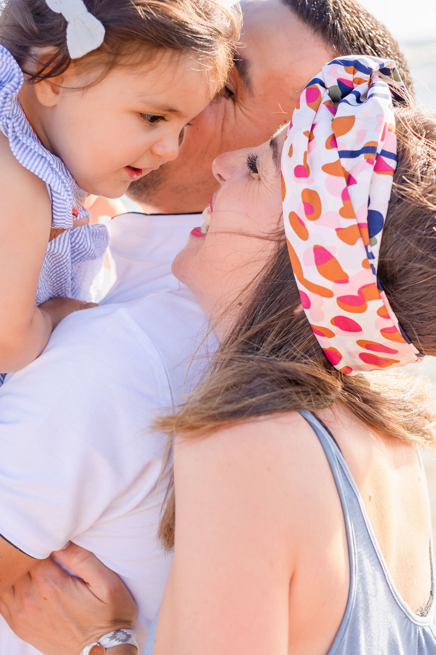 Intimate family moment shared on a sunny beach day.