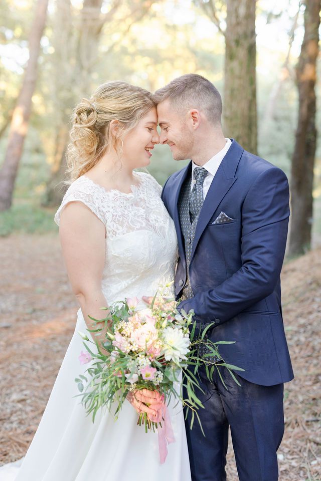 Romantic wedding portrait in forest with couple sharing intimate moment.
