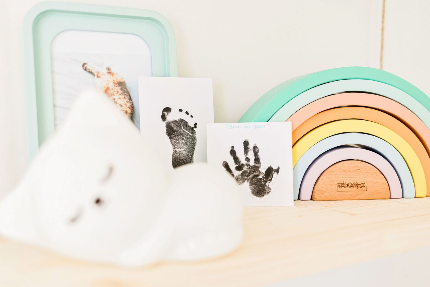 Mint green and pastel colored nursery decor items arranged in a minimalist style.
