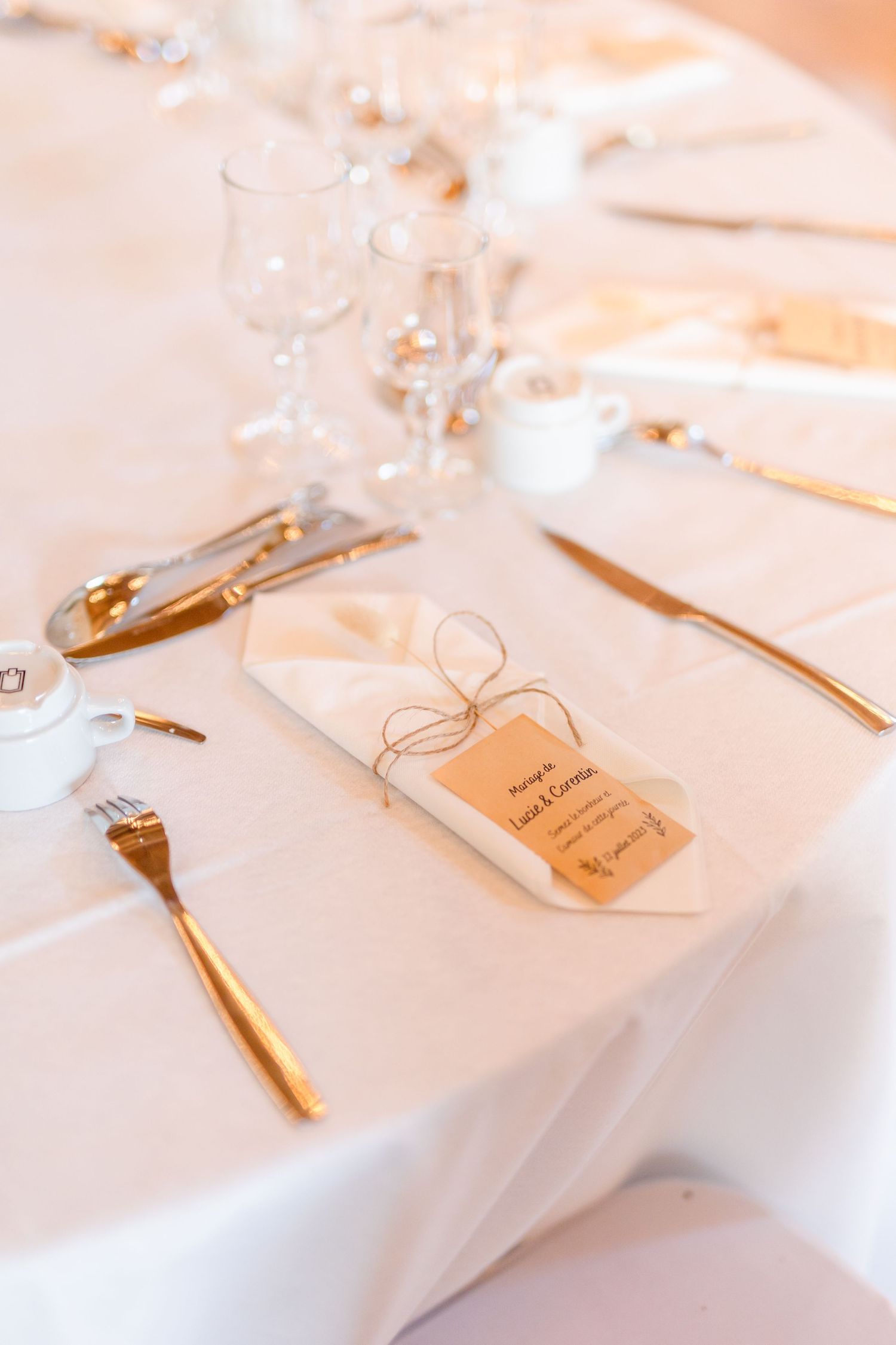 Elegant place settings with white napkins and name cards on dining table.