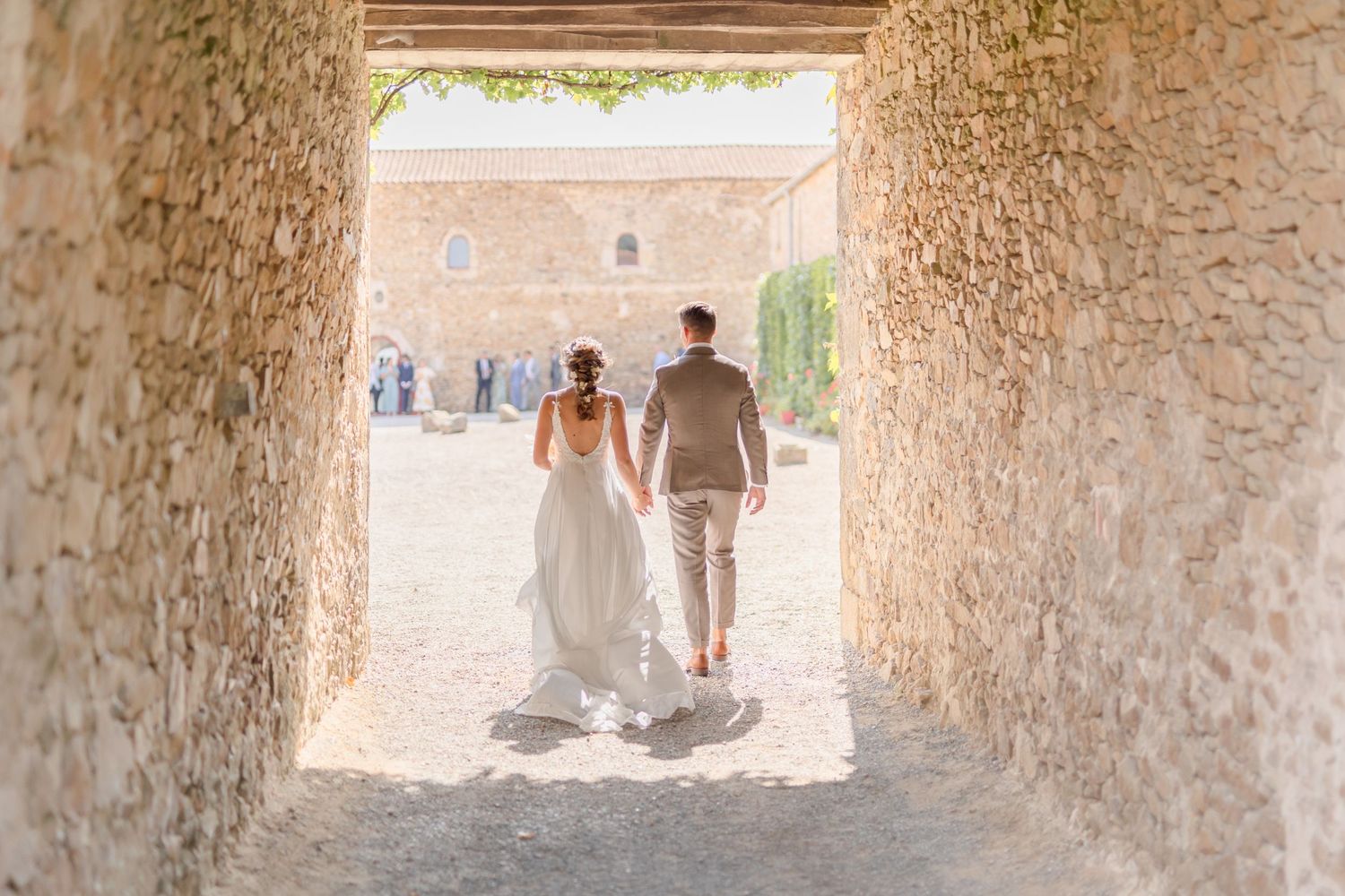 Stone archway tunnel with distant figures walking through.