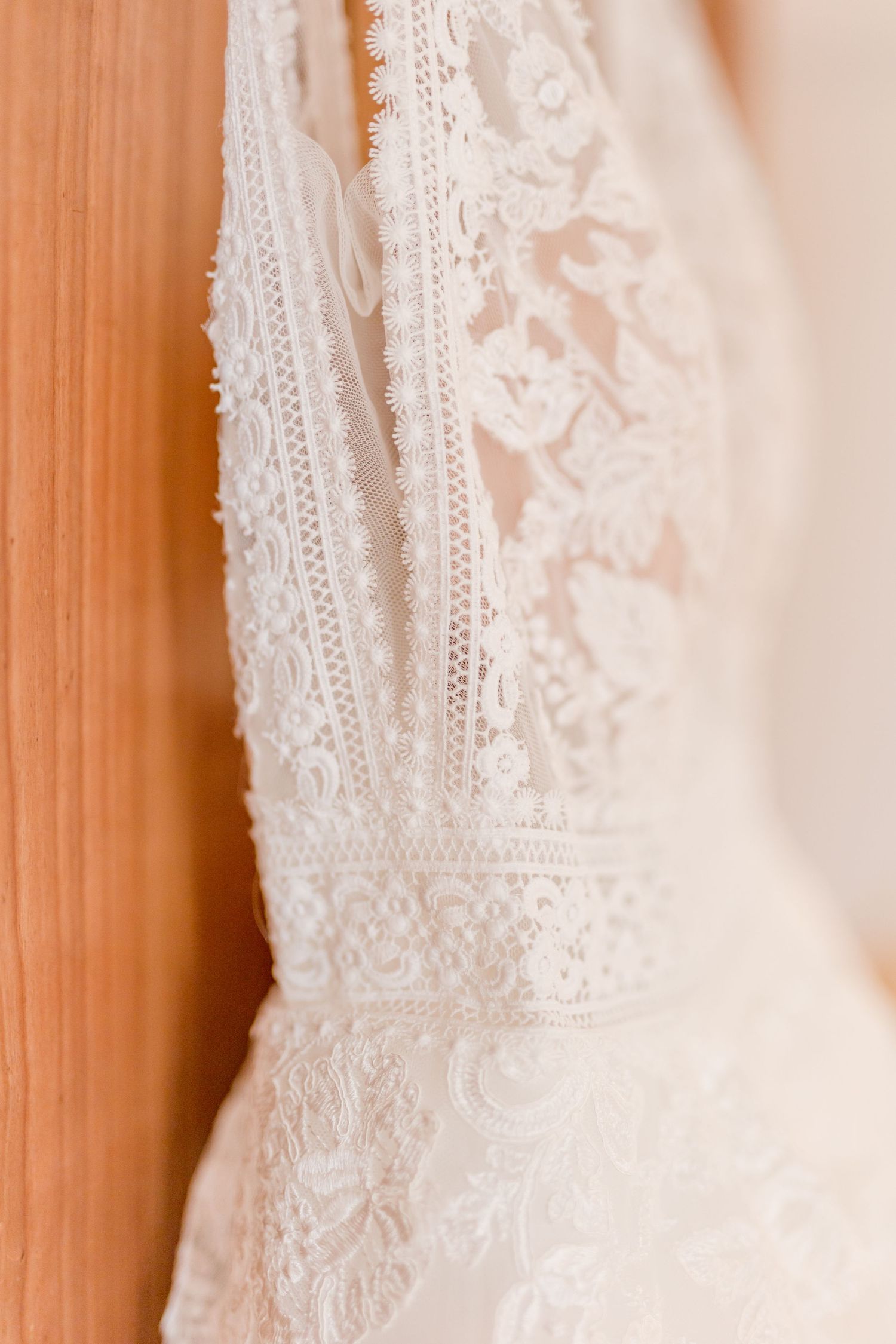 Close-up detail of delicate white lace and beading on a wedding dress bodice.