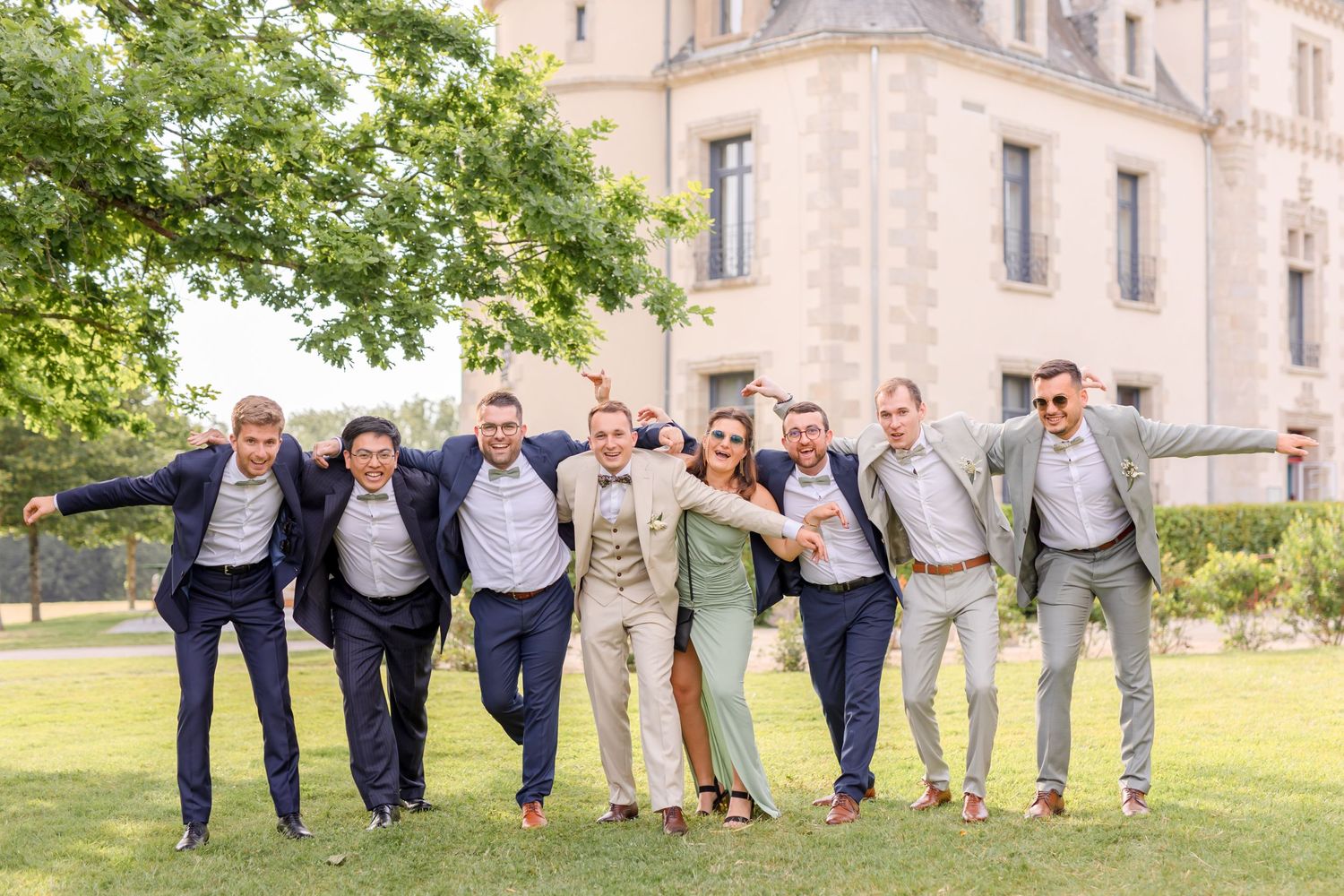 Fun wedding party photos show guests jumping and posing playfully outside historic building.