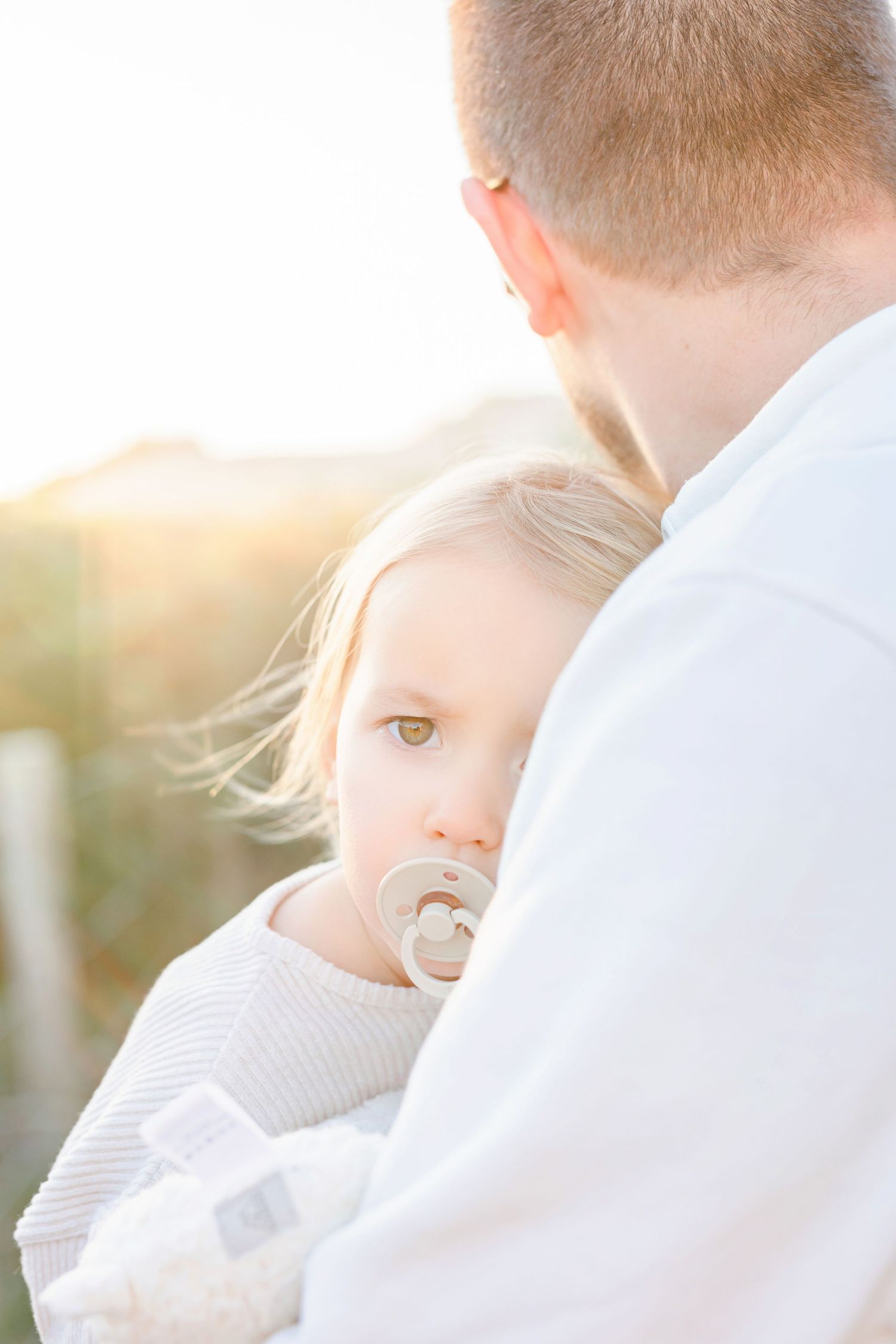 Tender moment between parent and child in soft sunlight.