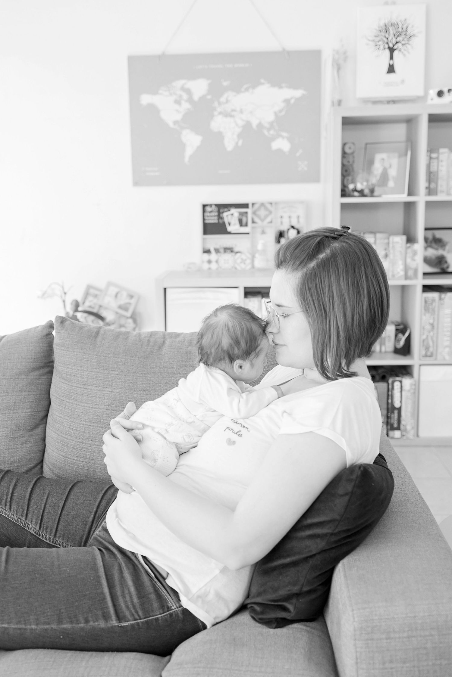 Family sitting together on a grey couch while playing music in a bright living room with world maps on the wall.