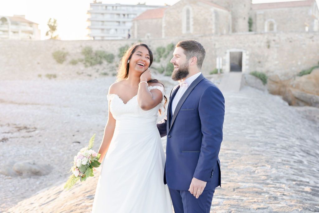Elegant wedding photography session on rustic cobblestone path by stone buildings.