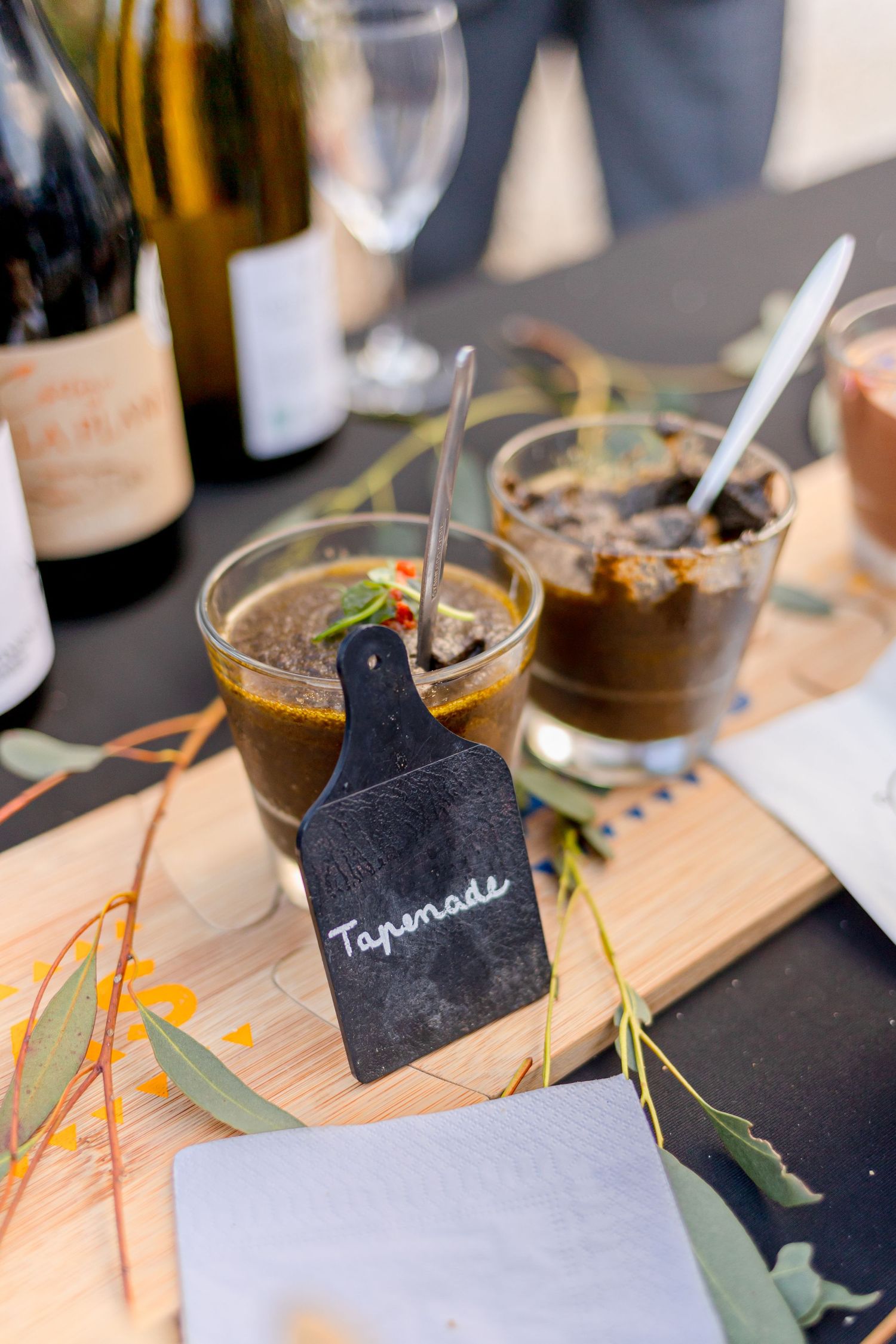 Appetizer serving board with tapenade and small black label marker.