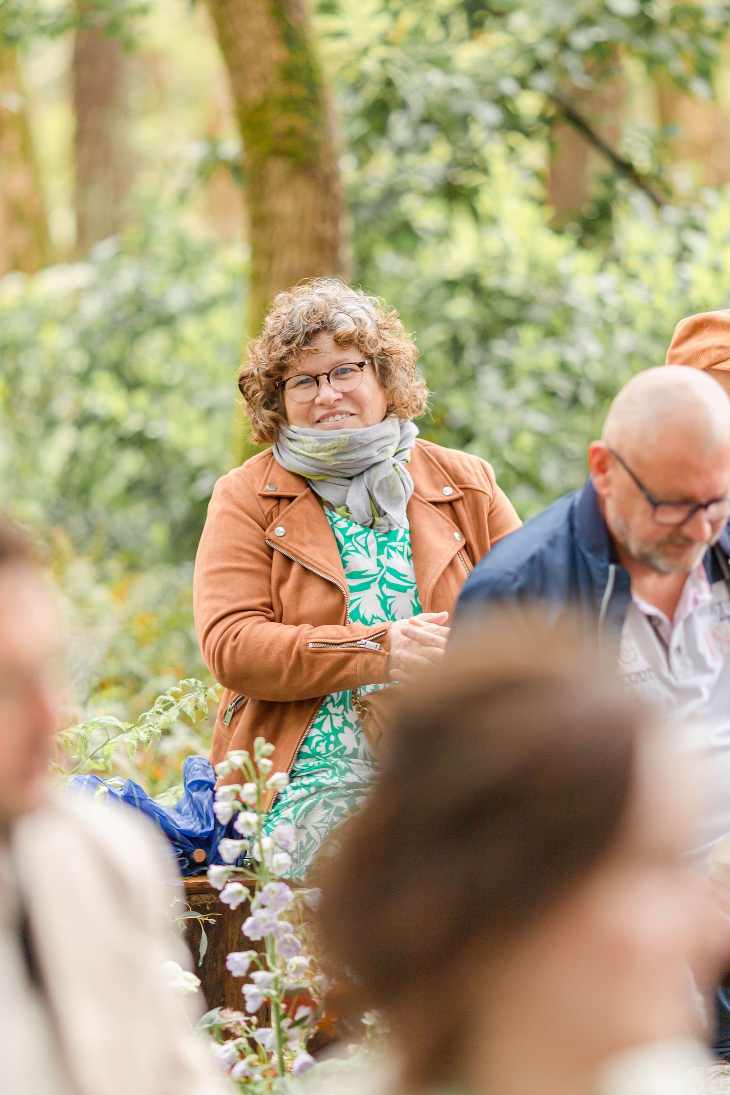 Wedding guests enjoying an outdoor ceremony in a wooded setting.