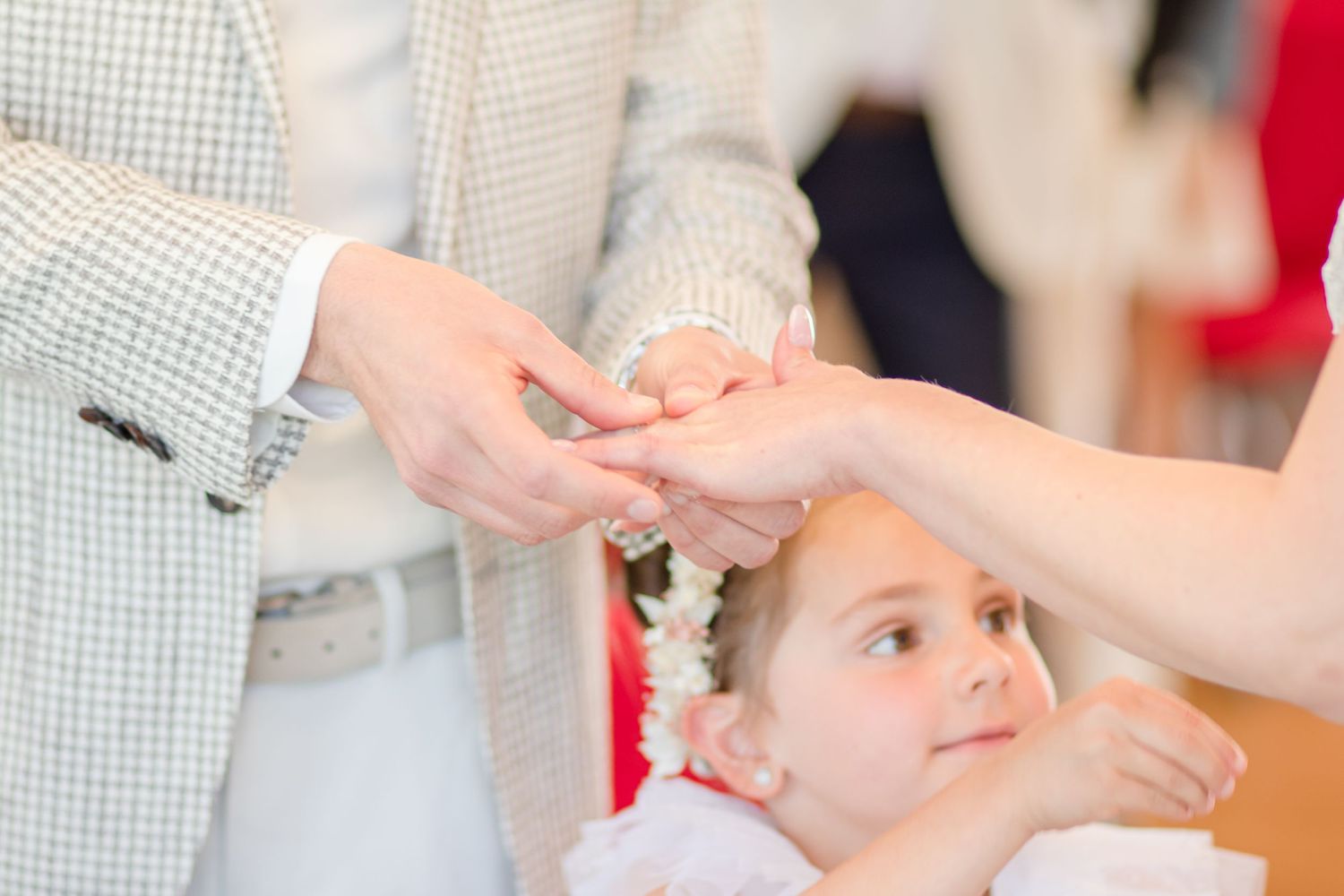Close-up of hands during an intimate wedding ceremony moment.