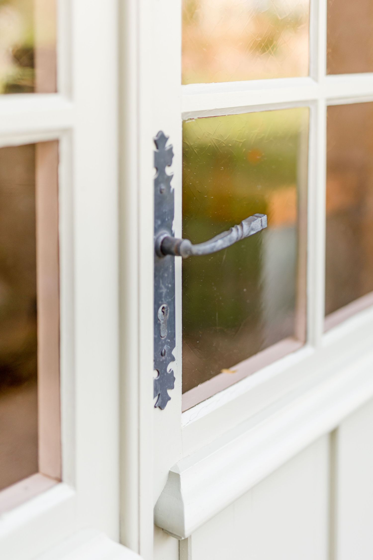 White-framed windows with traditional hardware details.