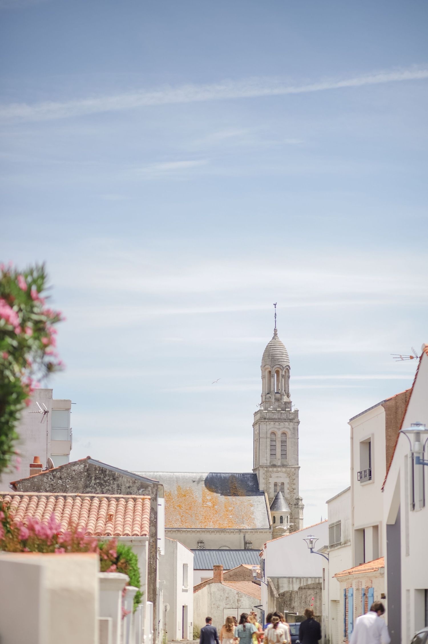Charming Mediterranean village street view with church tower and white buildings.