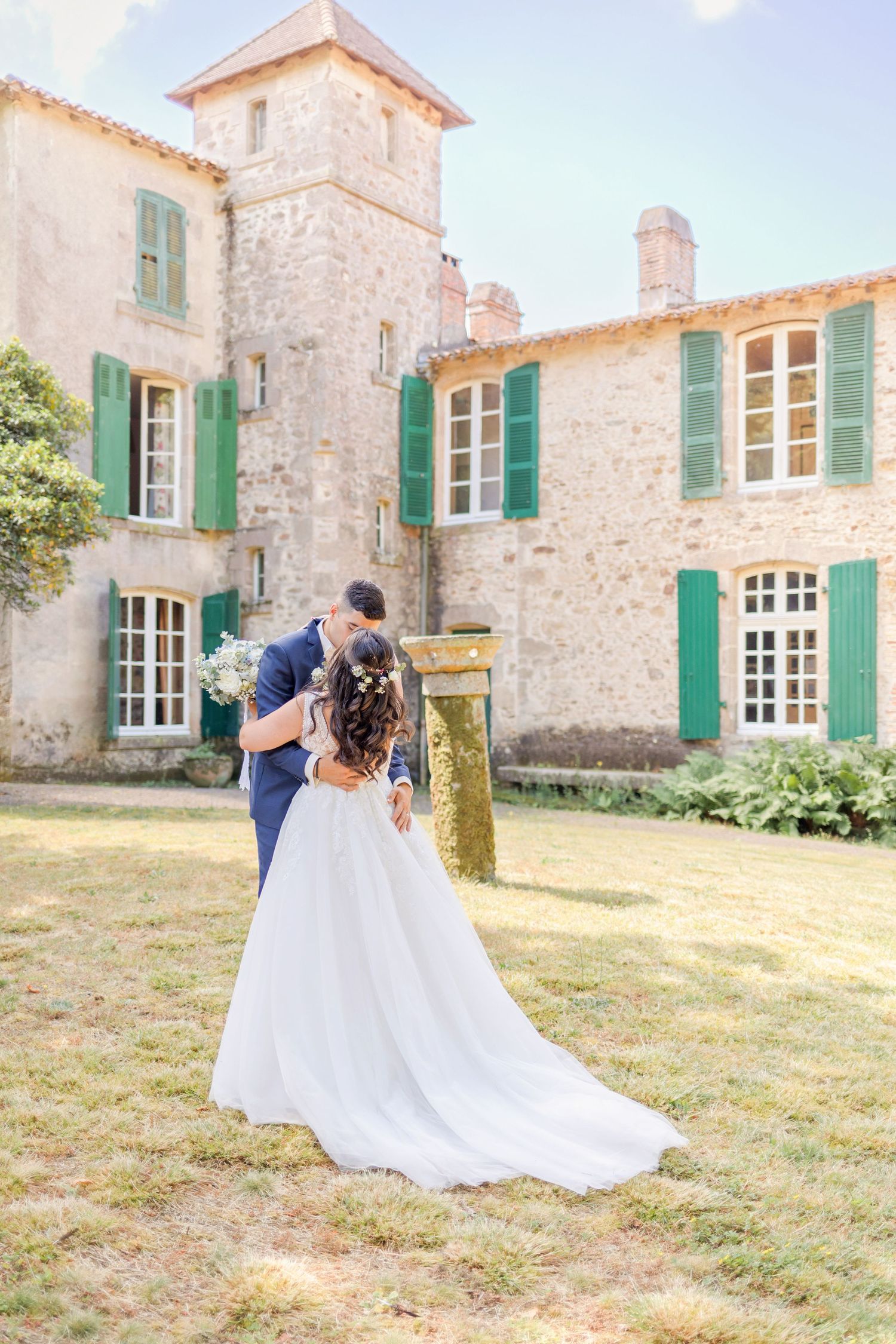 Romantic wedding photo session in front of stone villa with green shutters and Mediterranean architecture.