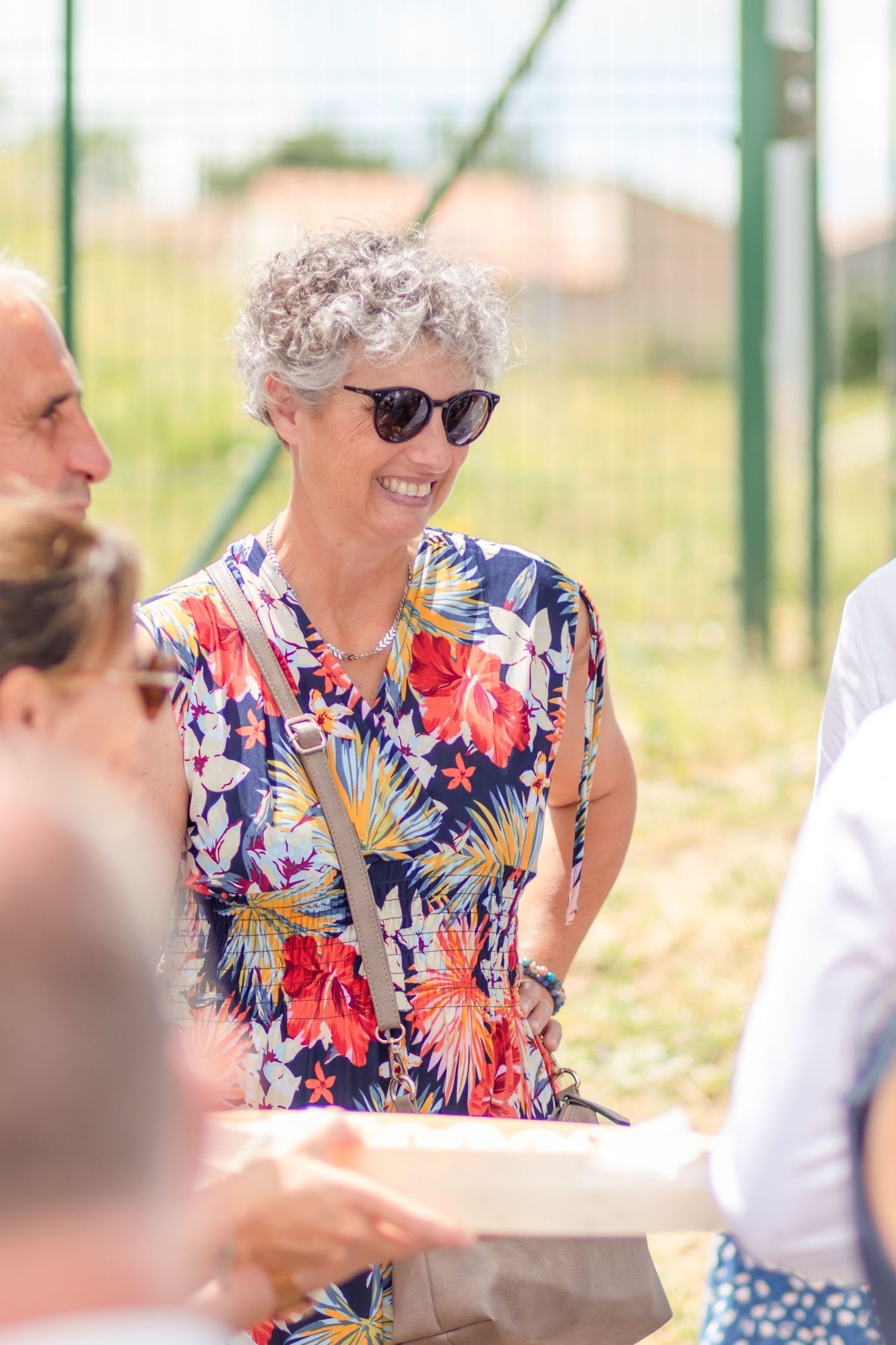 Guest in vibrant floral dress enjoying outdoor summer celebration.