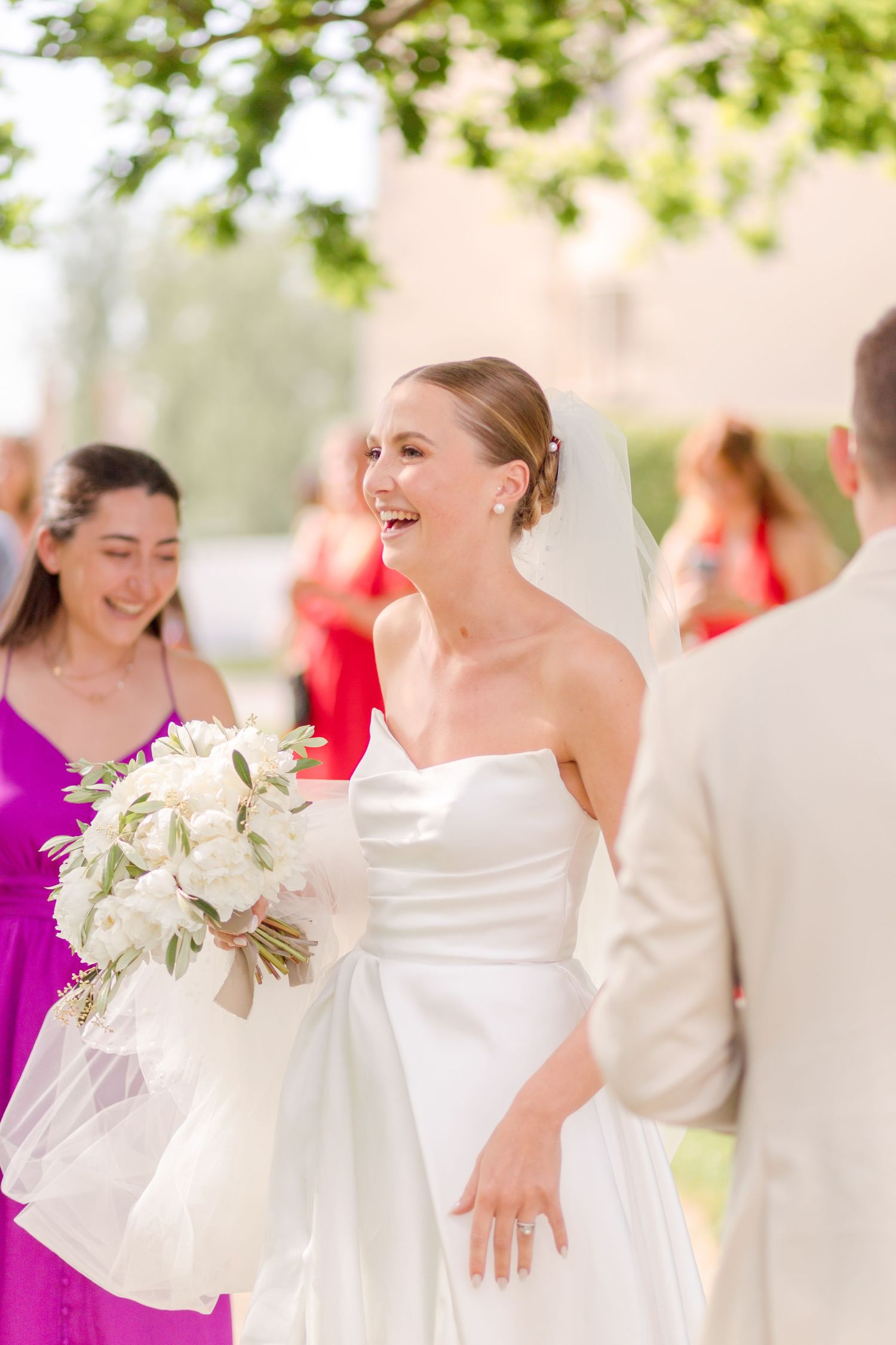 Wedding celebration outdoors with guests in formal attire.