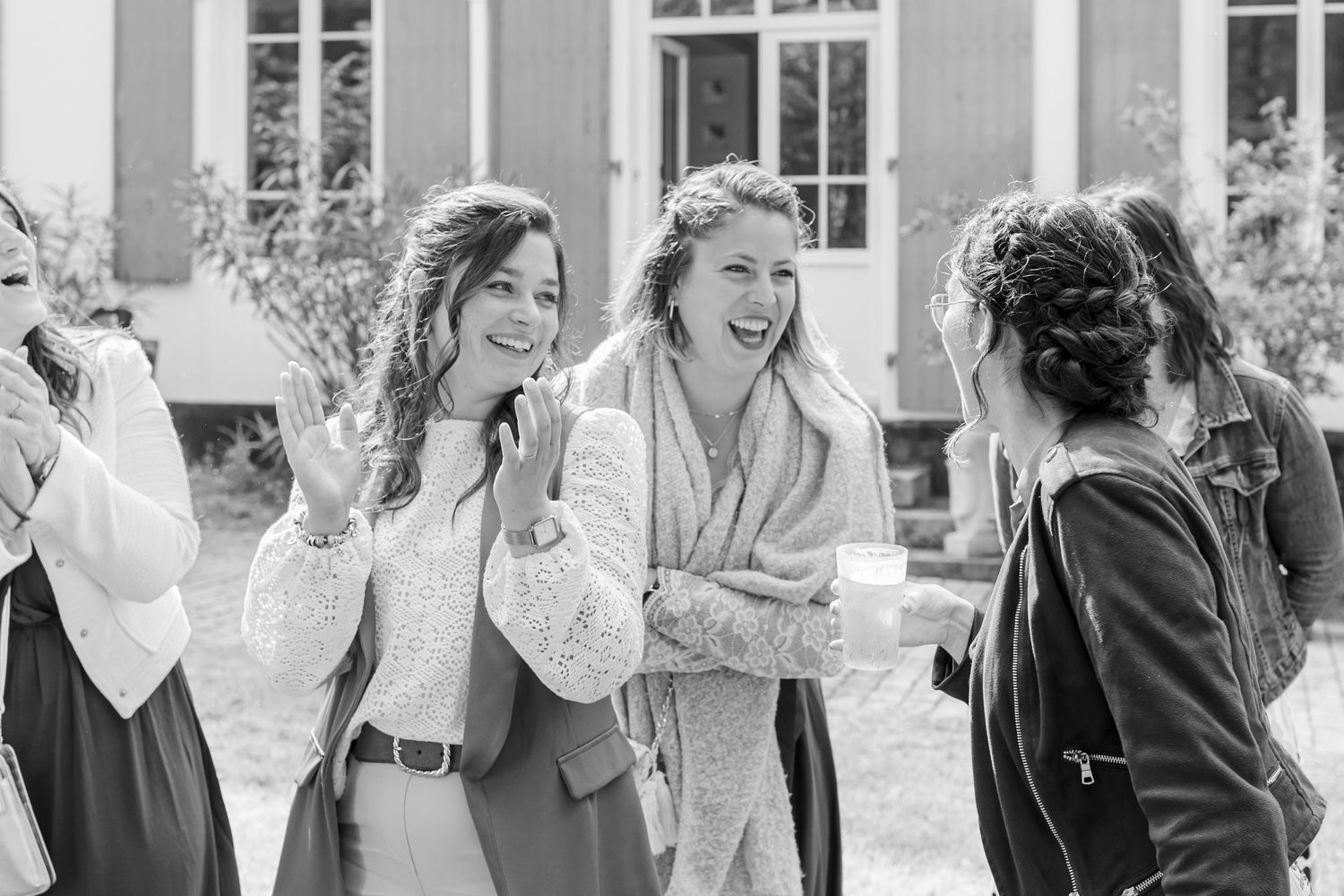 Candid black and white photo of joyful wedding celebration moments outdoors.