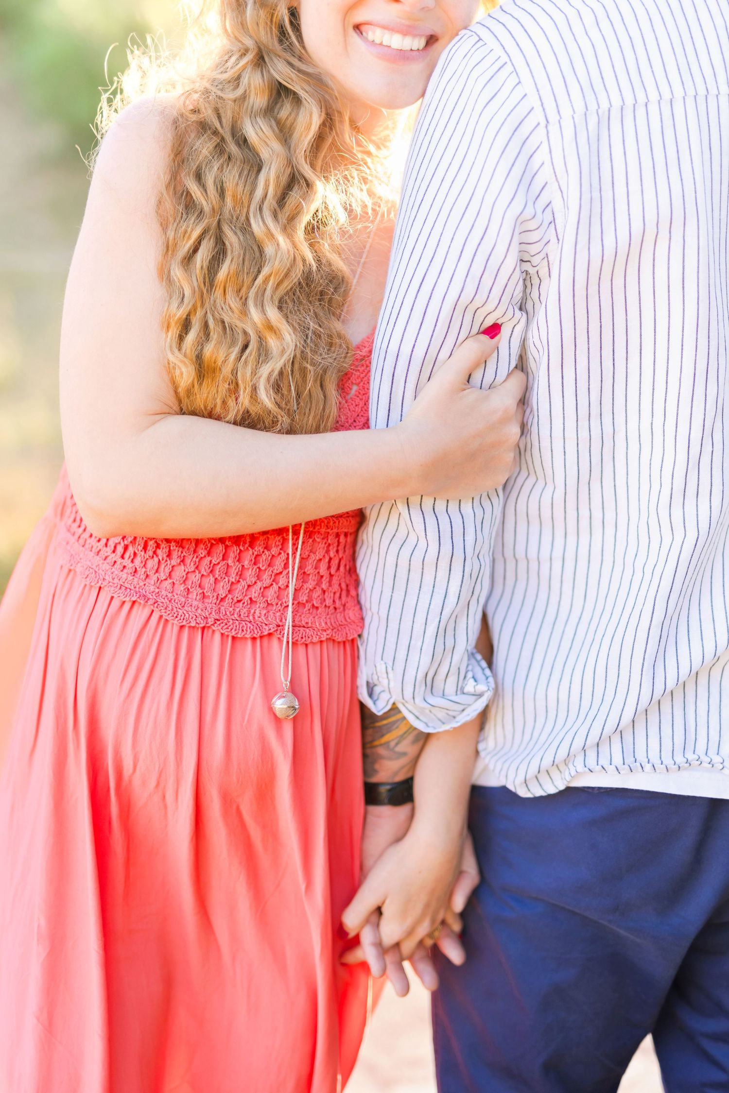 Sweet outdoor photo showing embracing couple against natural backdrop.