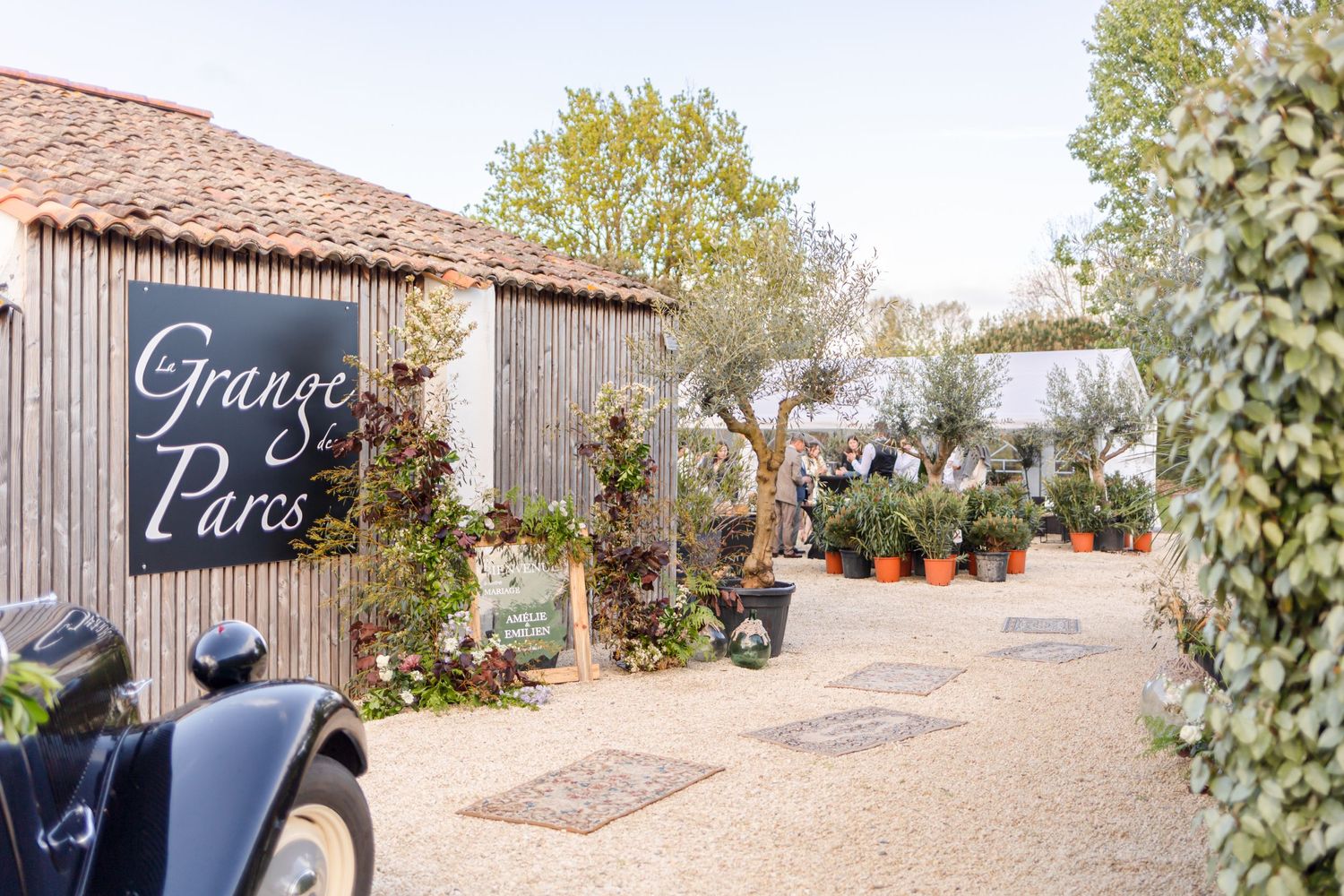 Rustic entrance to 'Georges Pares' venue with wooden siding and potted plants along a gravel path.