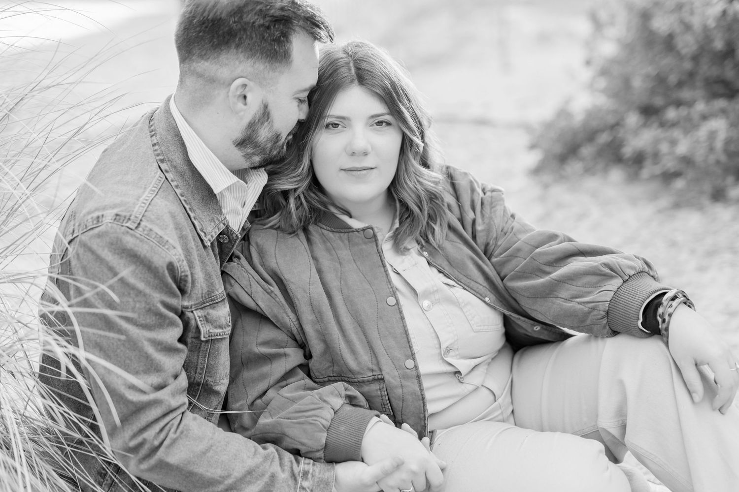 Black and white series capturing intimate moments between couple on beach.