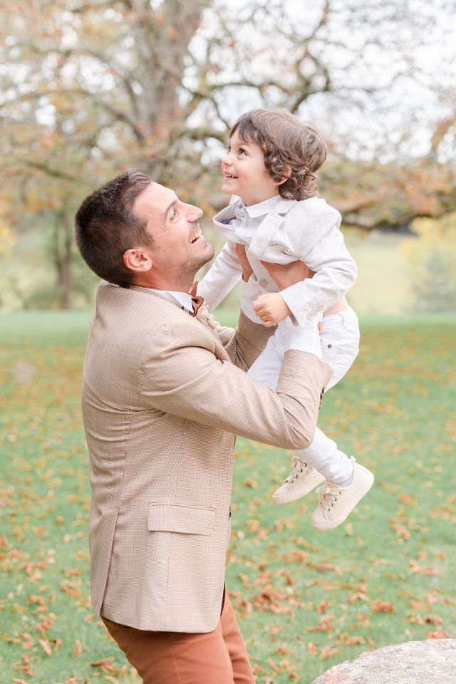 Candid outdoor portrait showing joyful interaction against autumn foliage.
