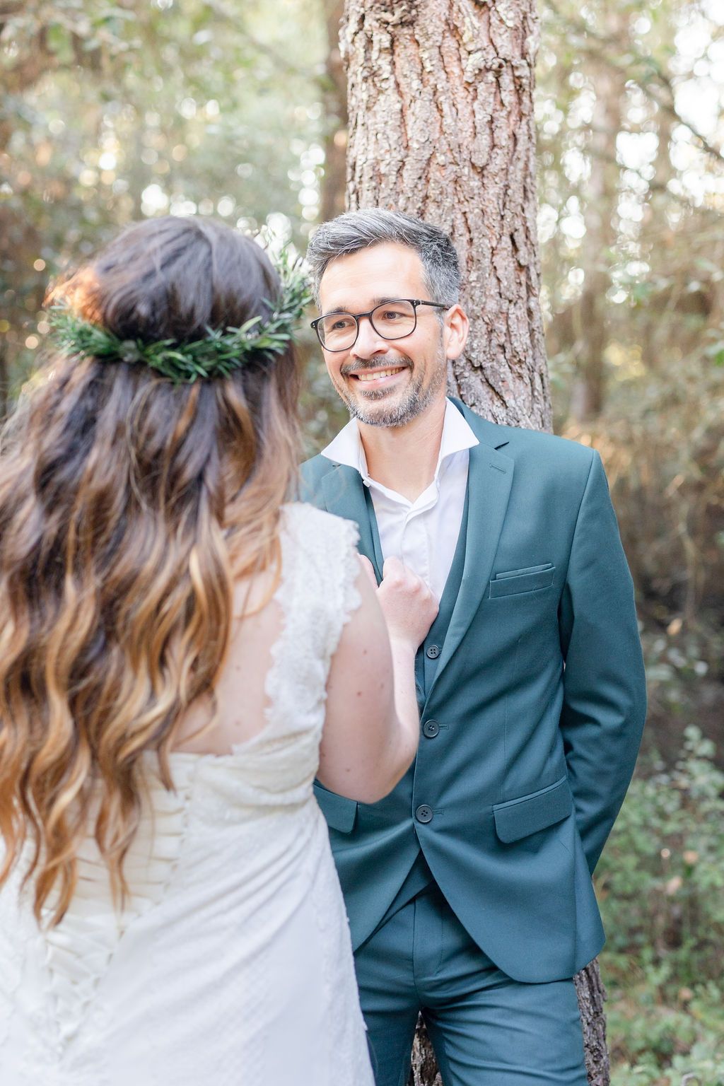 Playful wedding couple portraits against rustic tree backdrop with natural lighting.