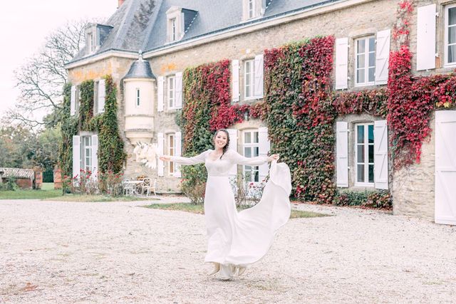 Ethereal scene of flowing white dress against historic chateau with climbing red ivy.