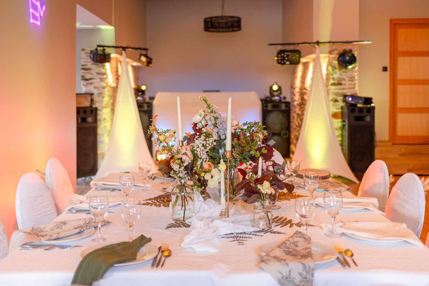 Elegant wedding reception tables with white linens and ambient lighting.