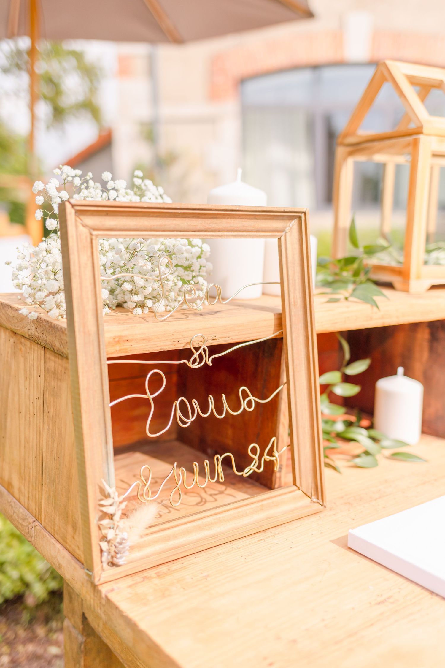 Decorative wooden display box with gold text and baby's breath flowers on wooden surface.