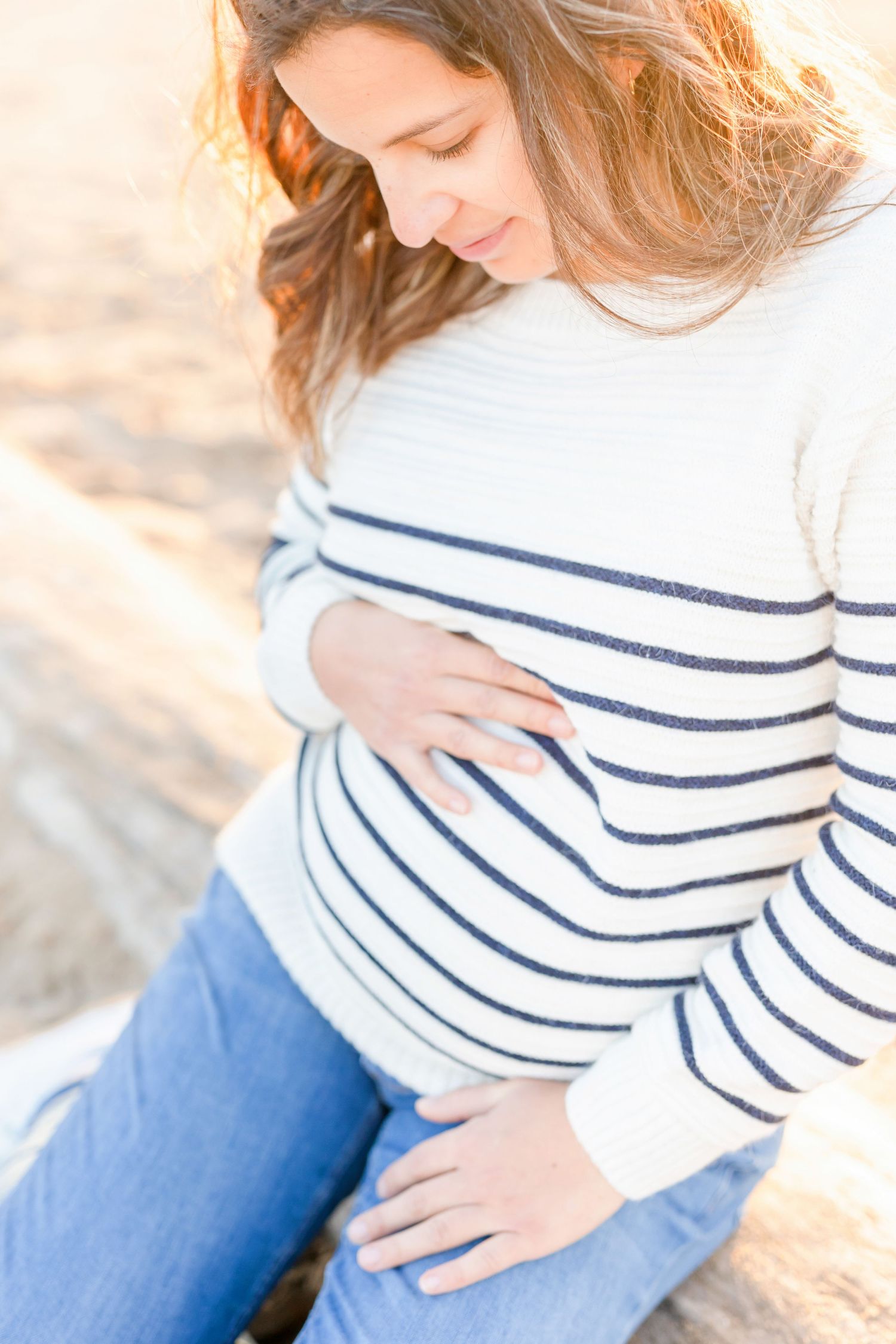 Close-up portrait on beach wearing white and navy striped sweater with natural lighting.
