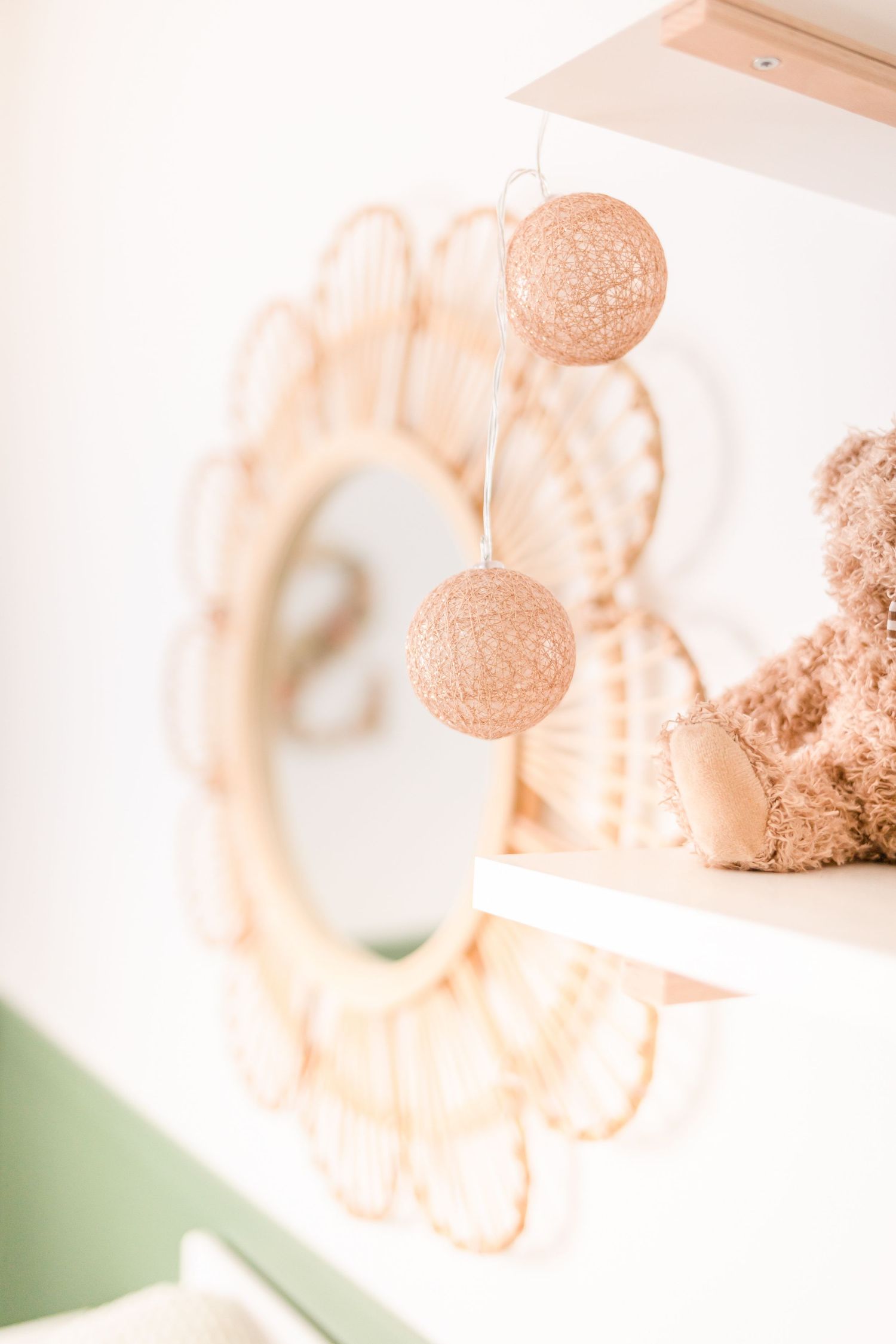 Delicate rose gold string lights and decor create a soft, dreamy nursery atmosphere.