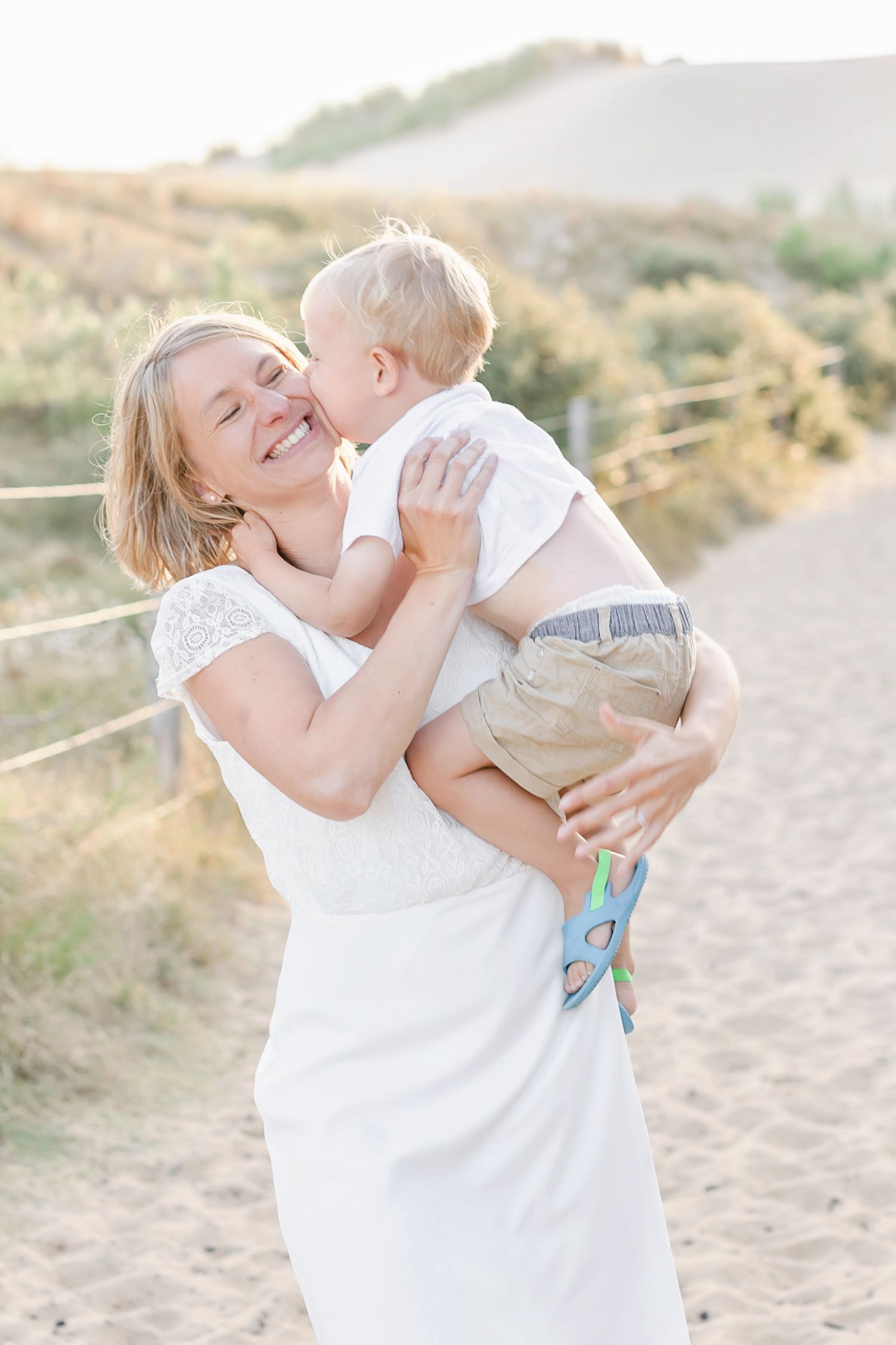 Tender family interactions captured on a sandy beach path.