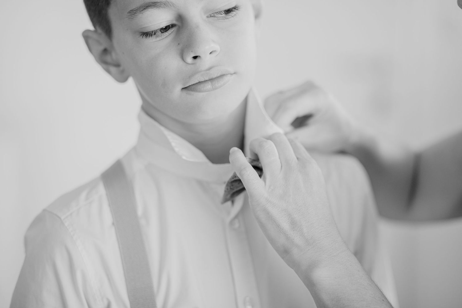 Close up detail of careful adjustments being made to formal attire.