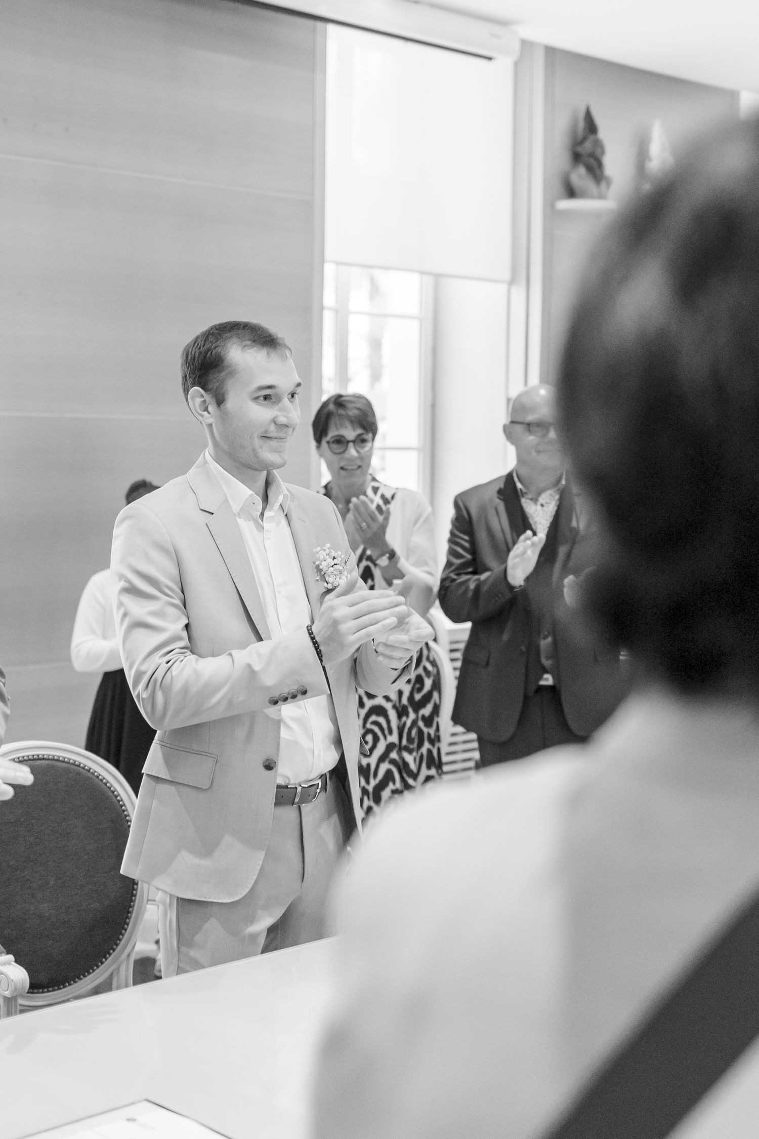 A candid black and white photo capturing a joyful moment during a wedding ceremony.