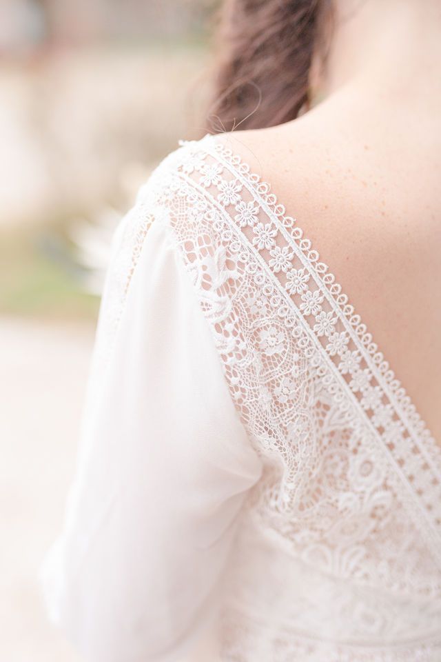 Delicate lace trim detail on shoulder of white wedding dress.