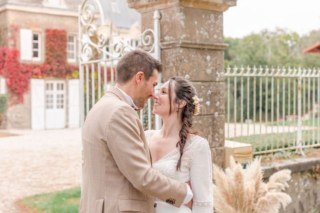 Romantic wedding photoshoot in front of an elegant stone mansion with red ivy in autumn.