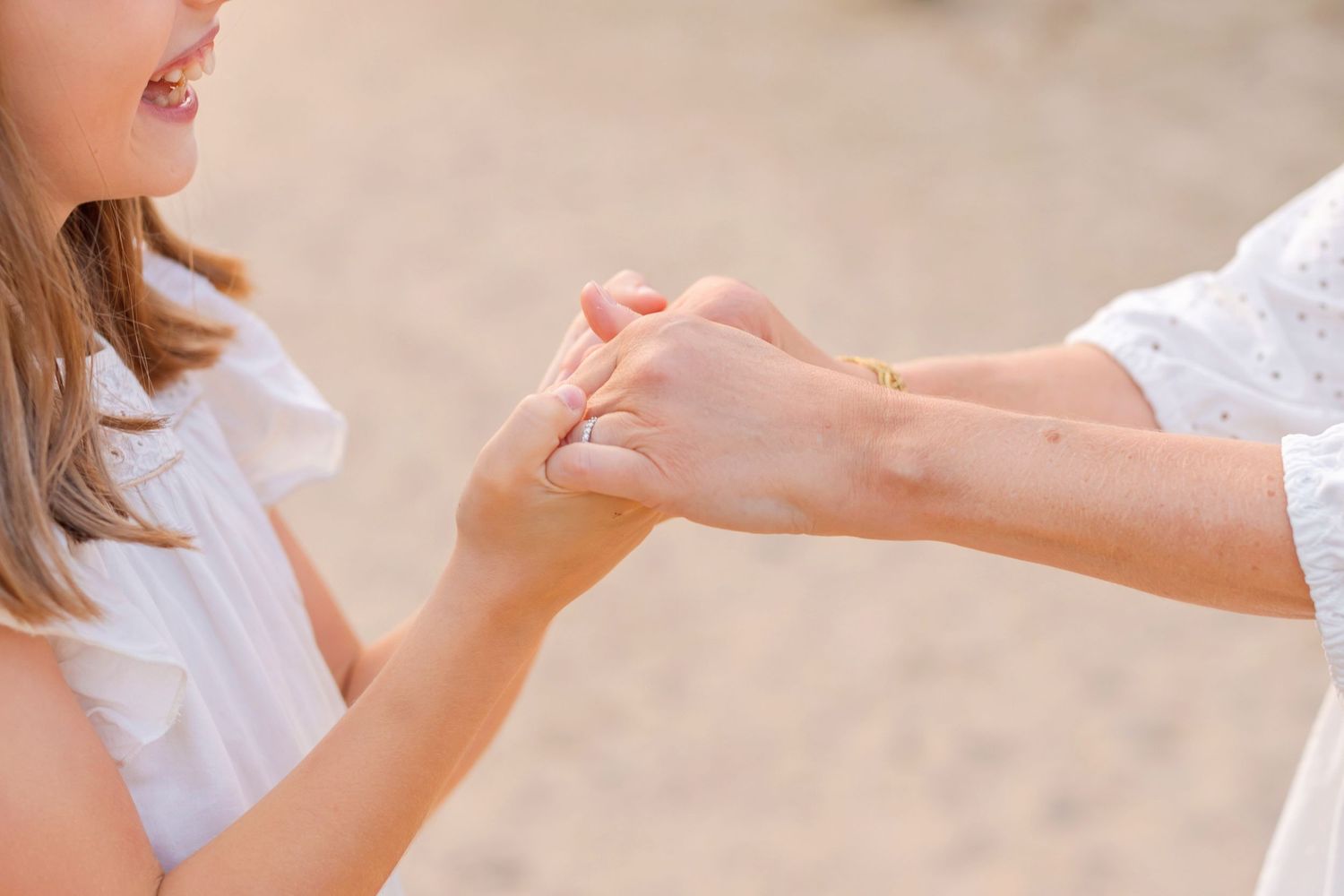 Close-up of hands touching in tender moment on sunny outdoor path.