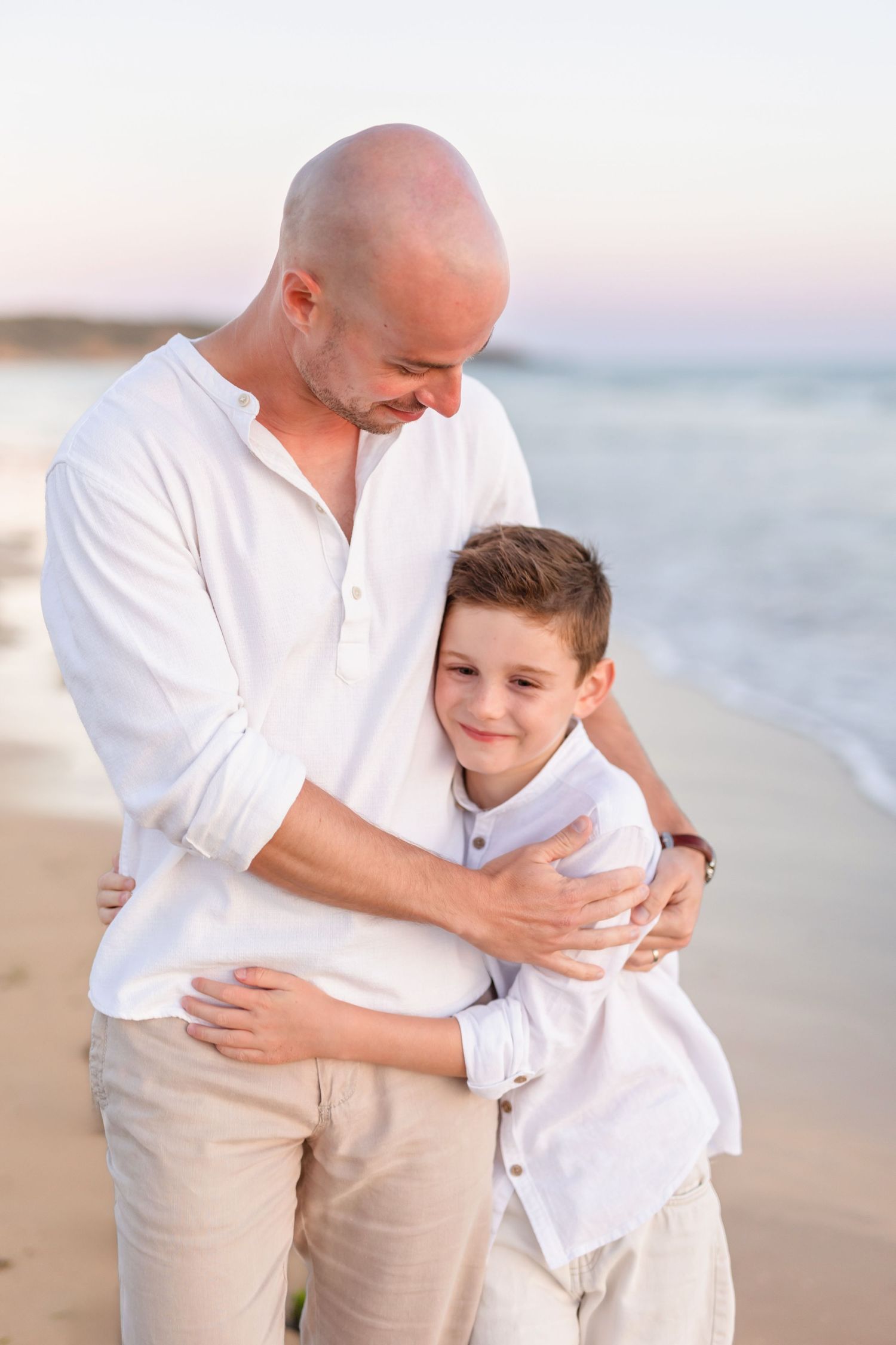 Sweet embrace shared between parent and child on a peaceful beach at dusk.
