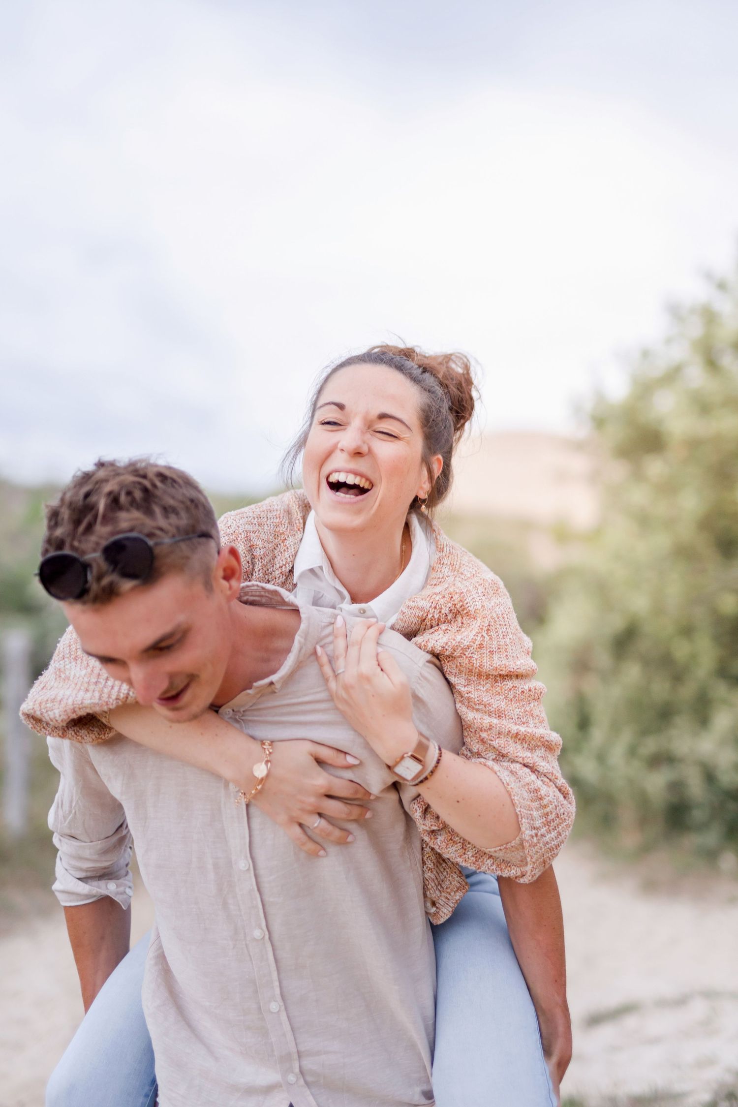 Playful piggyback ride on outdoor trail with joyful laughter.