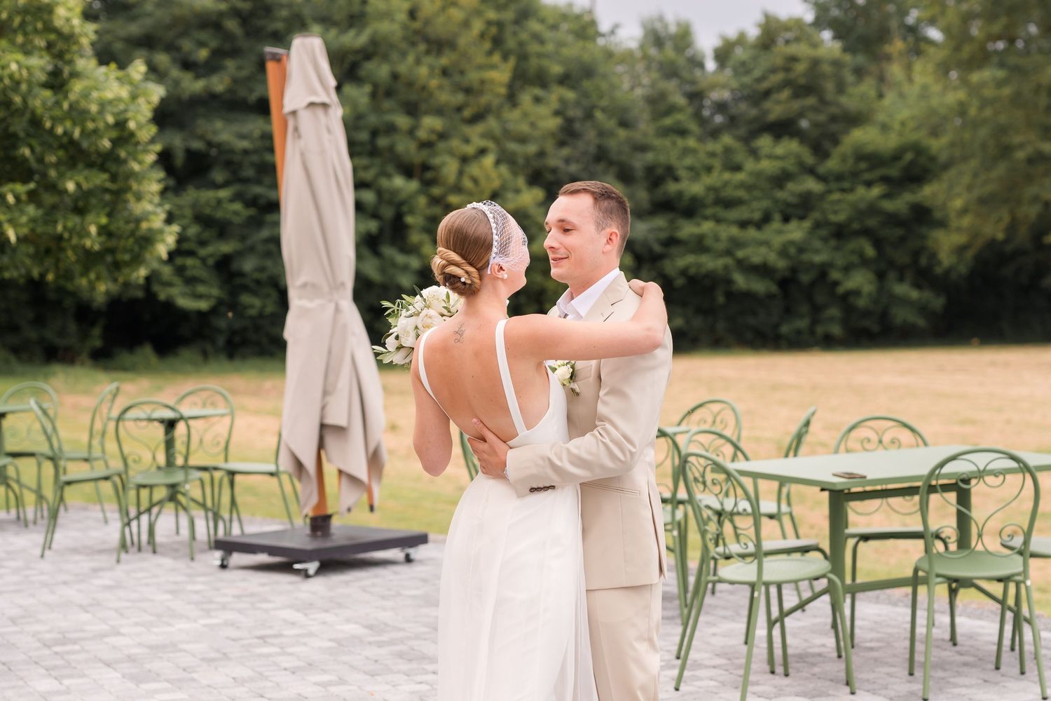 Outdoor wedding scene with green garden chairs and elegant venue setting.
