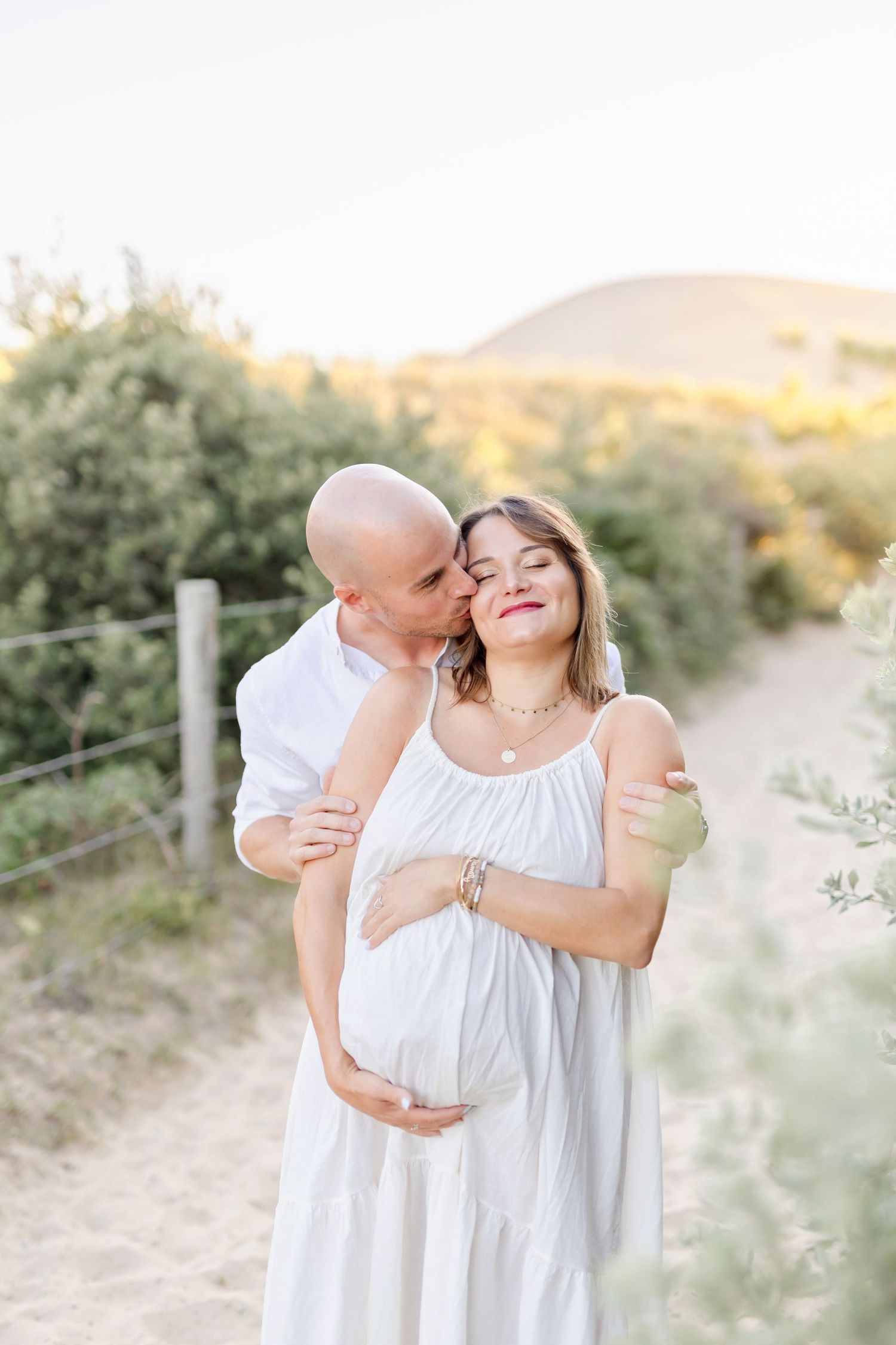 Intimate maternity portrait on a nature trail with mountain views in the background.