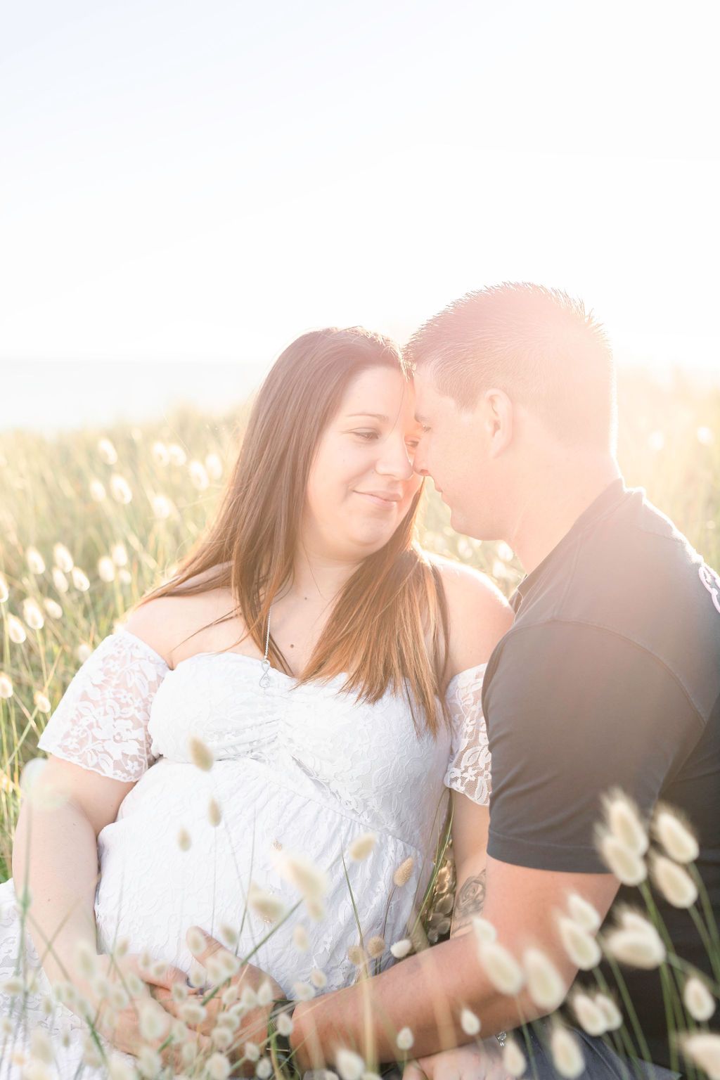 Sunlight filters through wildflowers as a couple shares an intimate moment.